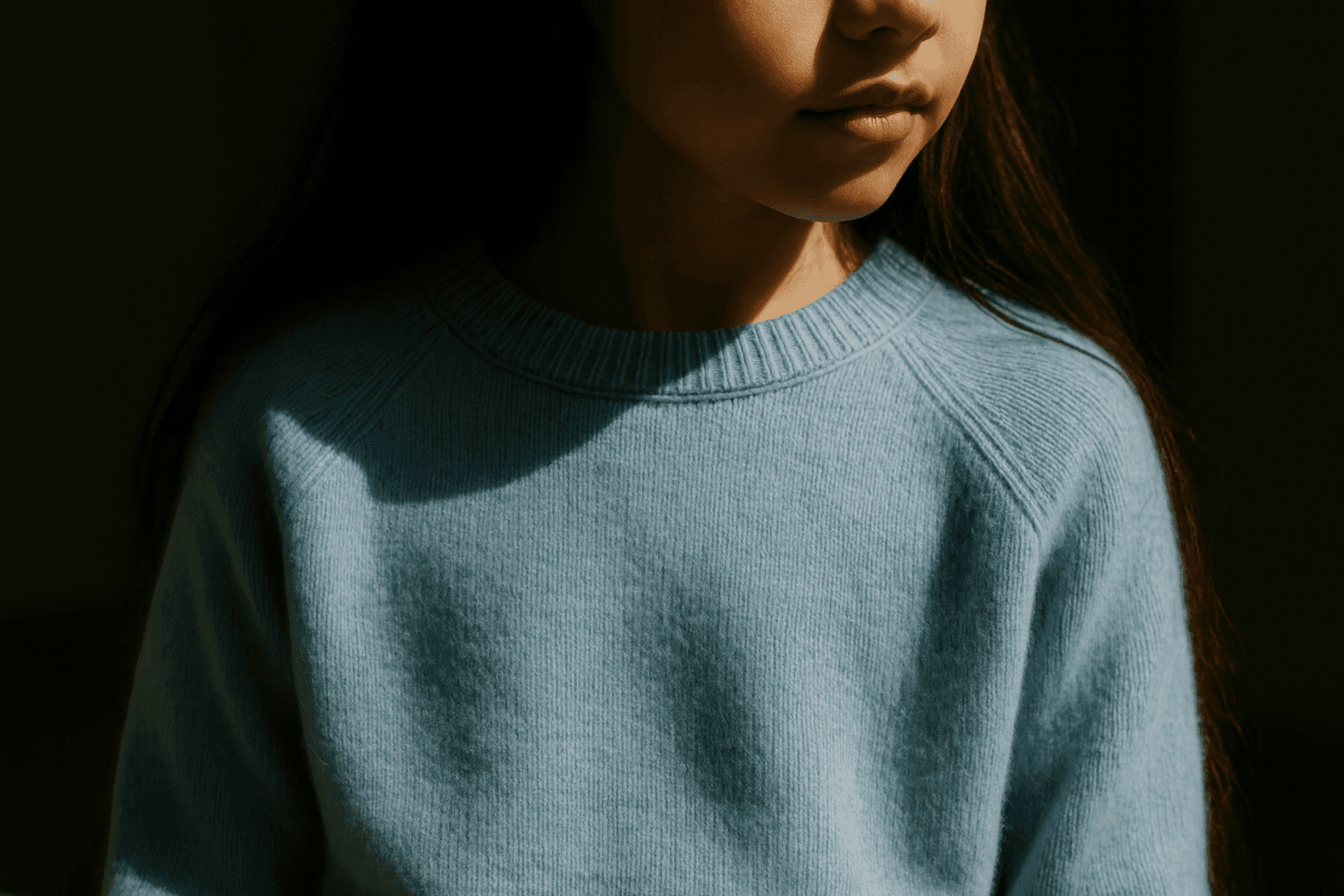 Close-up of girl with a wooly light blue sweater