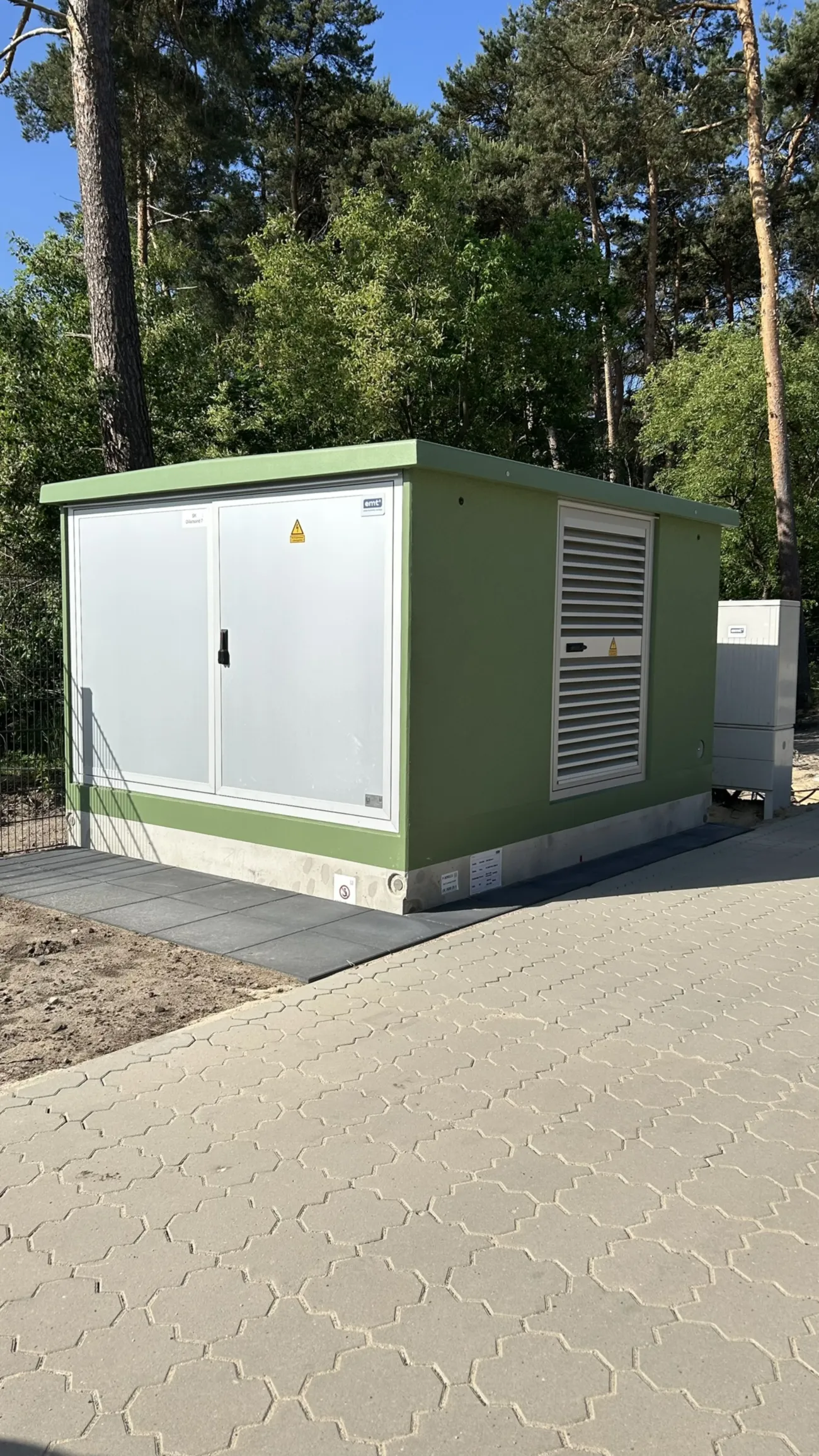 Luftaufnahme eines Bauernhofs mit Biogasanlage, Solaranlagen und Feldern.