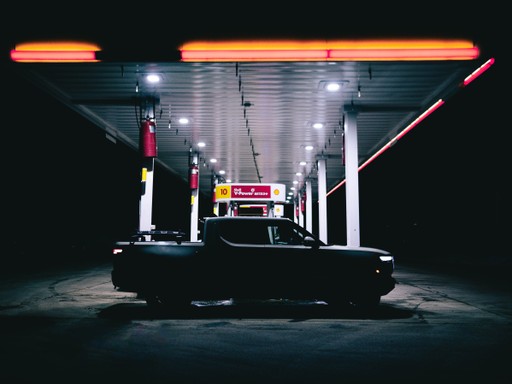 A close-up of a person wearing green-tinted glasses, with a serious expression and smooth skin.