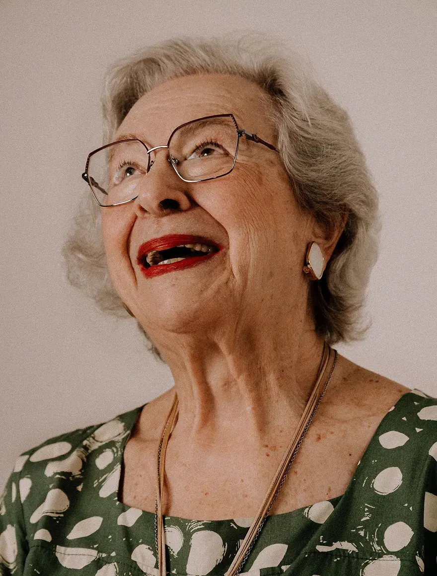 Senior woman smiling and looking upward during a social activity.