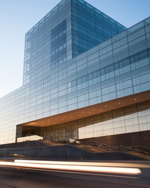 A monolithic glass building rreflecting blue light.