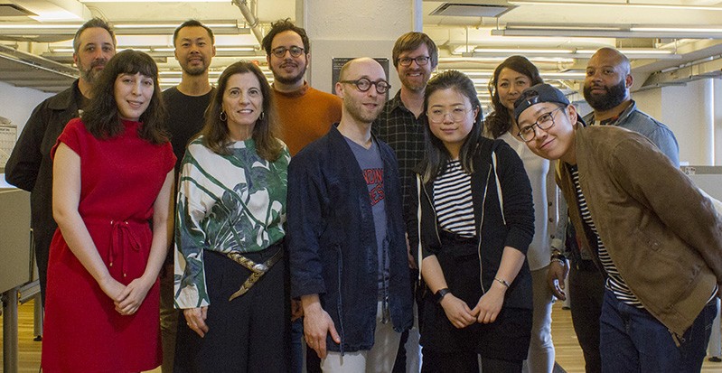 A photo of a group of people standing in an office.