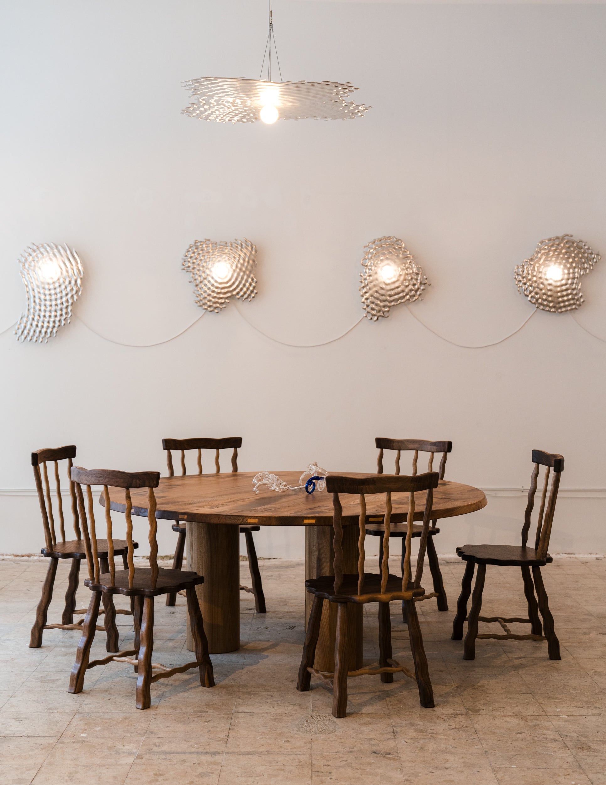 Set of six walnut Windsor dining chairs around a round dining table