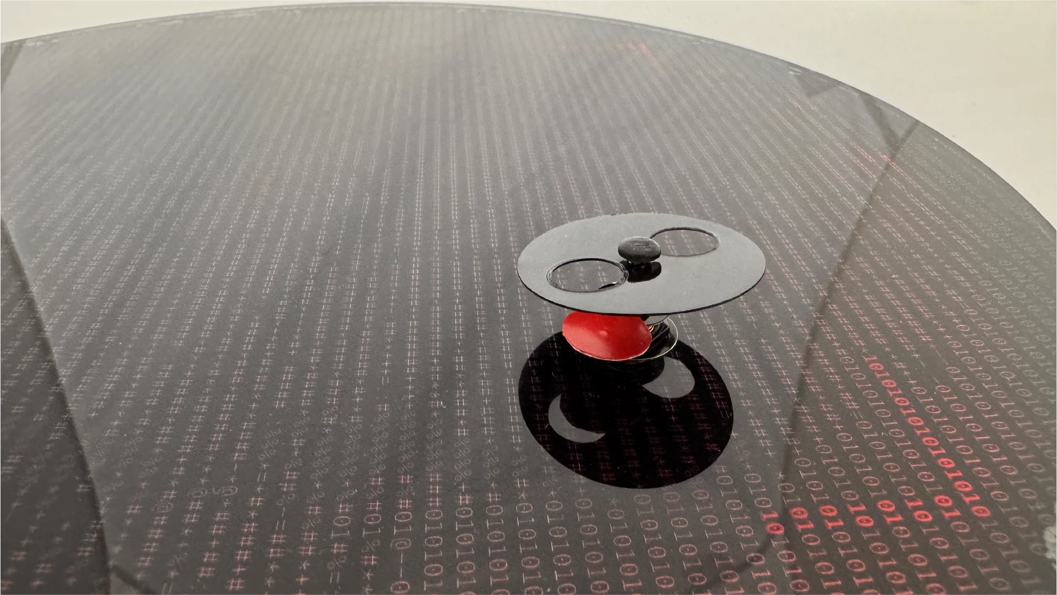 As the minute hand turns, the hour hand is reavealed through circular cutouts, mimicking a blinking red light.