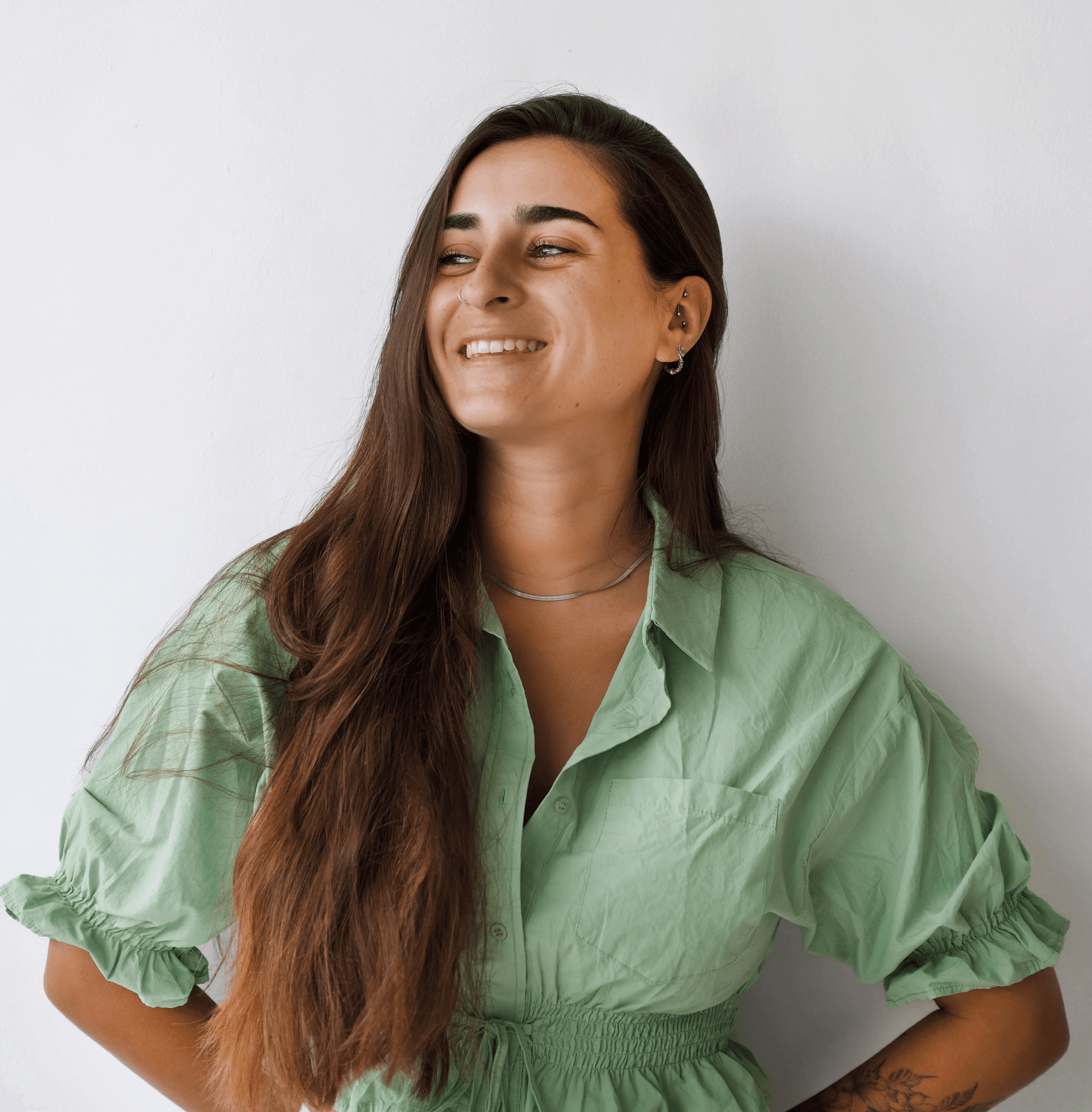 Portrait of a laughing person with curly hair wearing a white shirt