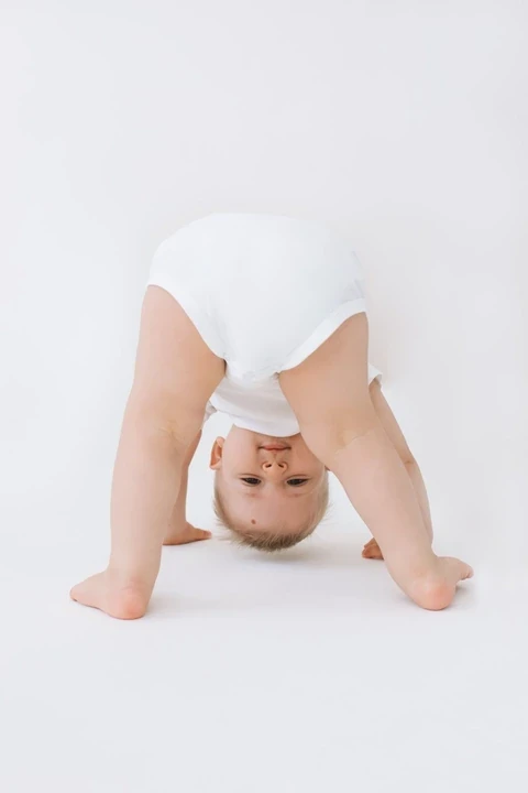 Playful baby peeking upside down between their legs