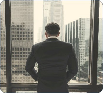 man putting hands on pocket while standing in front of glass wall