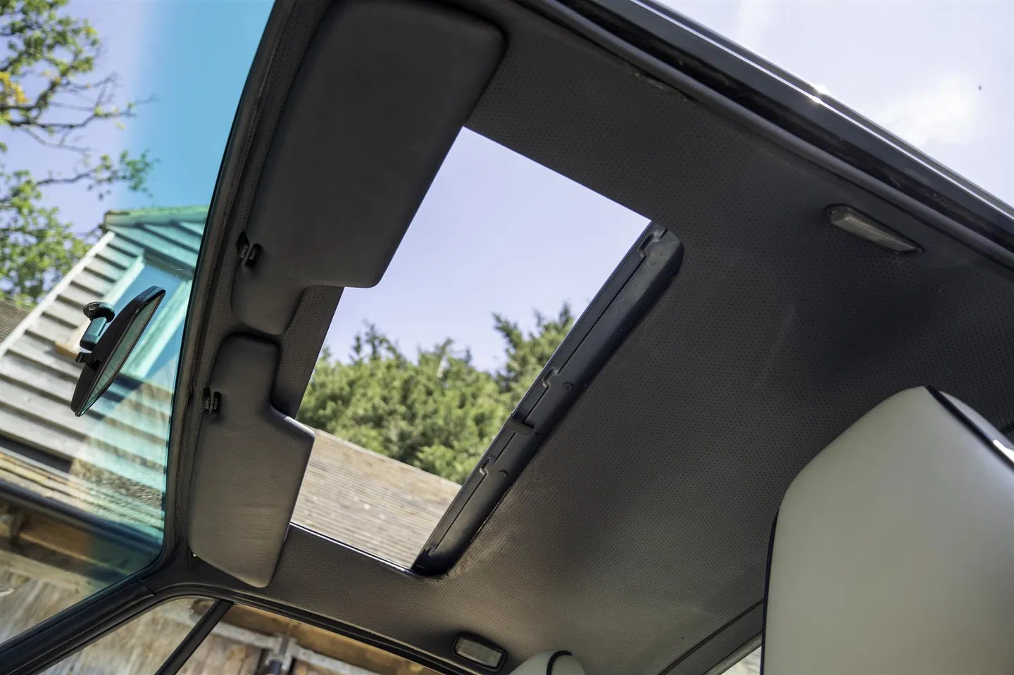 Open electric sliding sunroof viewed from inside the cabin