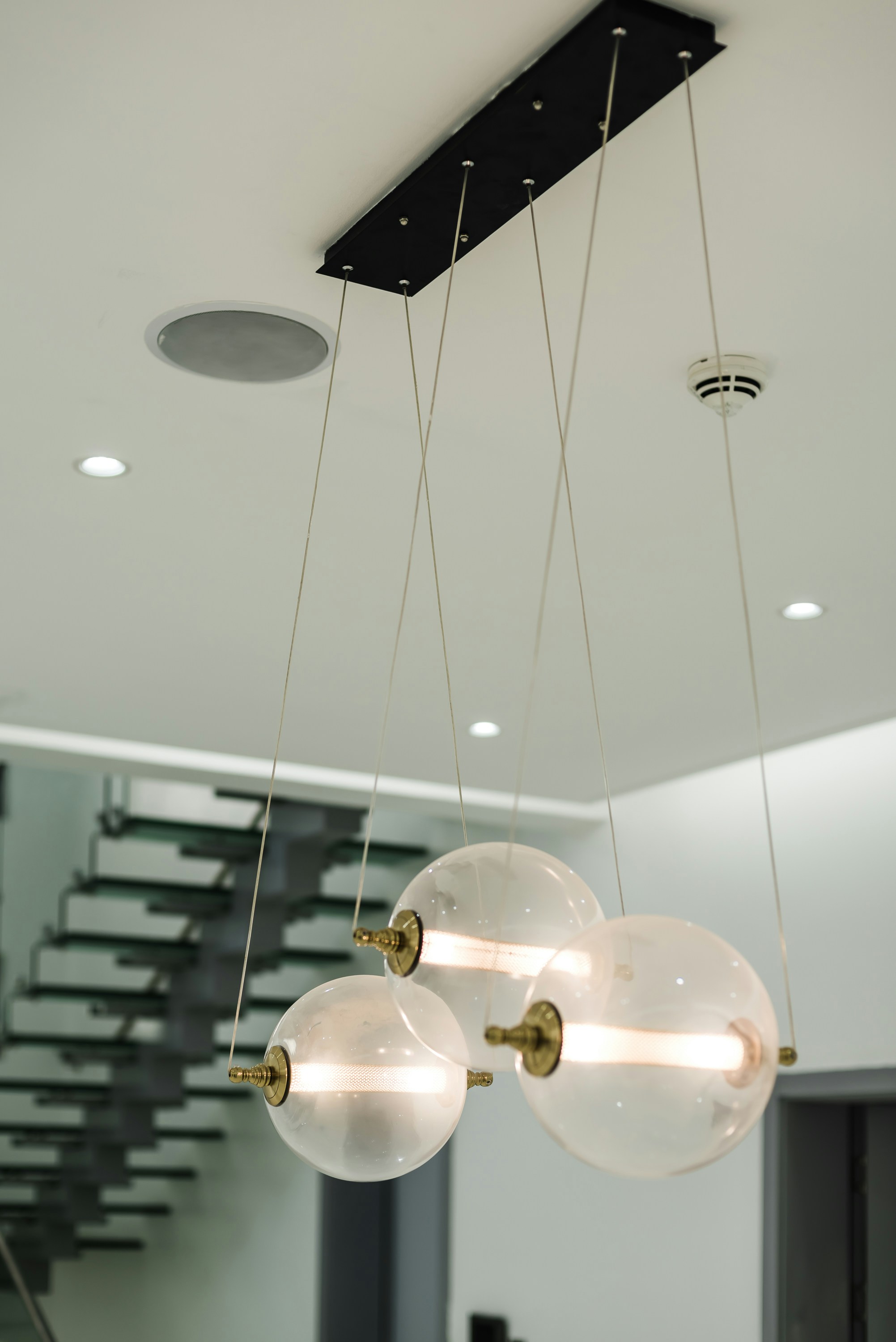 High ceilings with recessed lighting and a modern staircase.