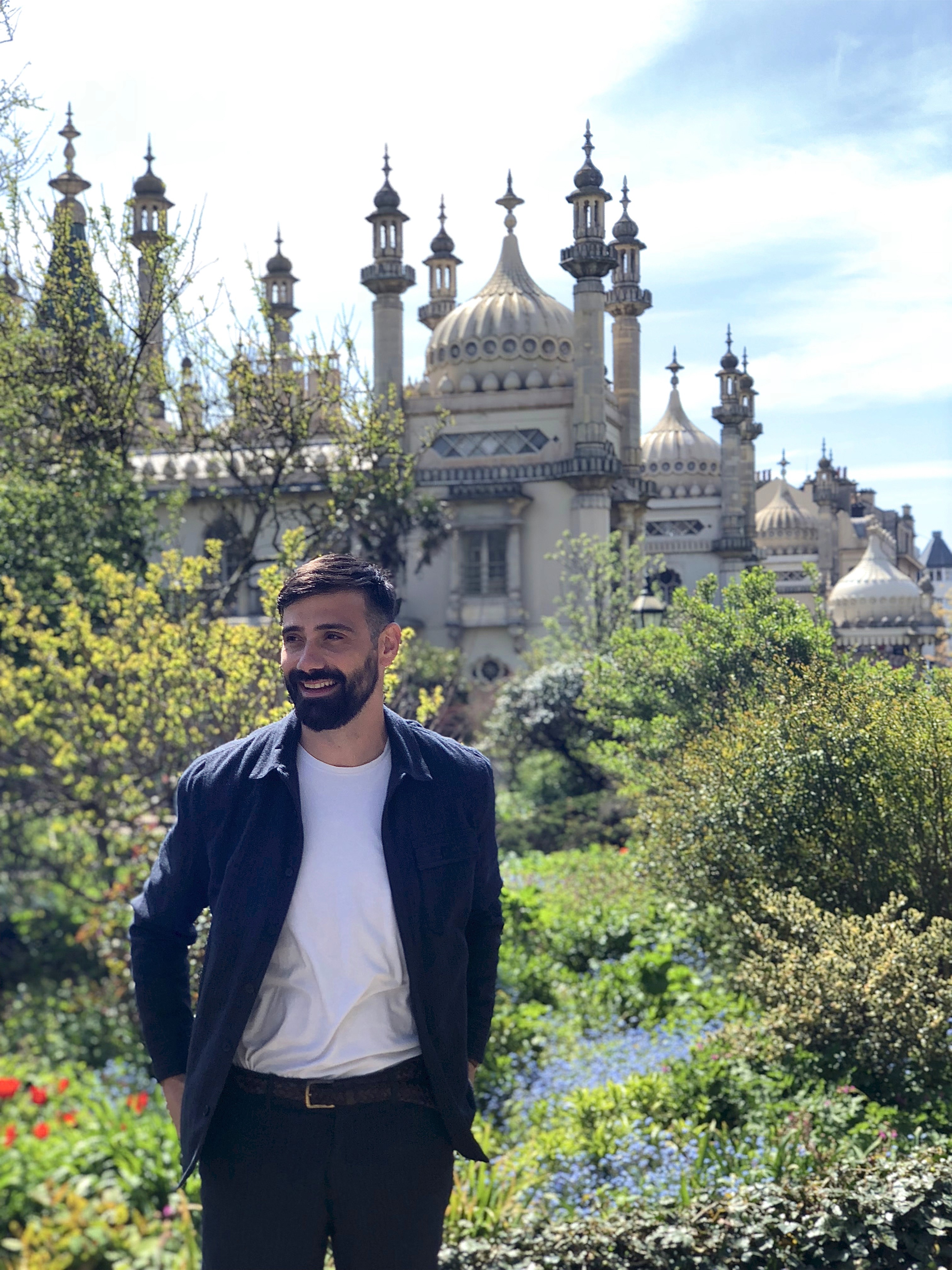 A thoughtful young person with dark hair gazes to the side, captured in soft black and white lighting.
