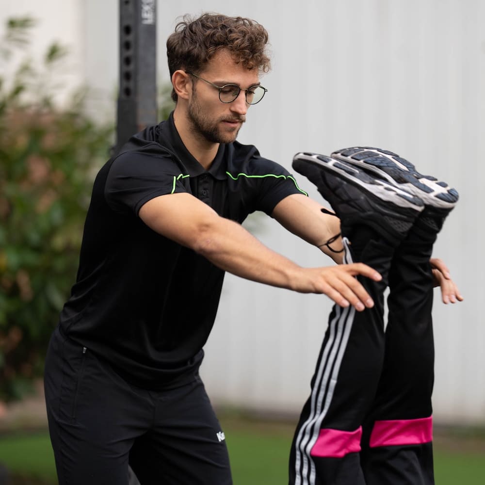 Lukas Kazimierski dehnt im Einzeltraining das Bein eines Klienten