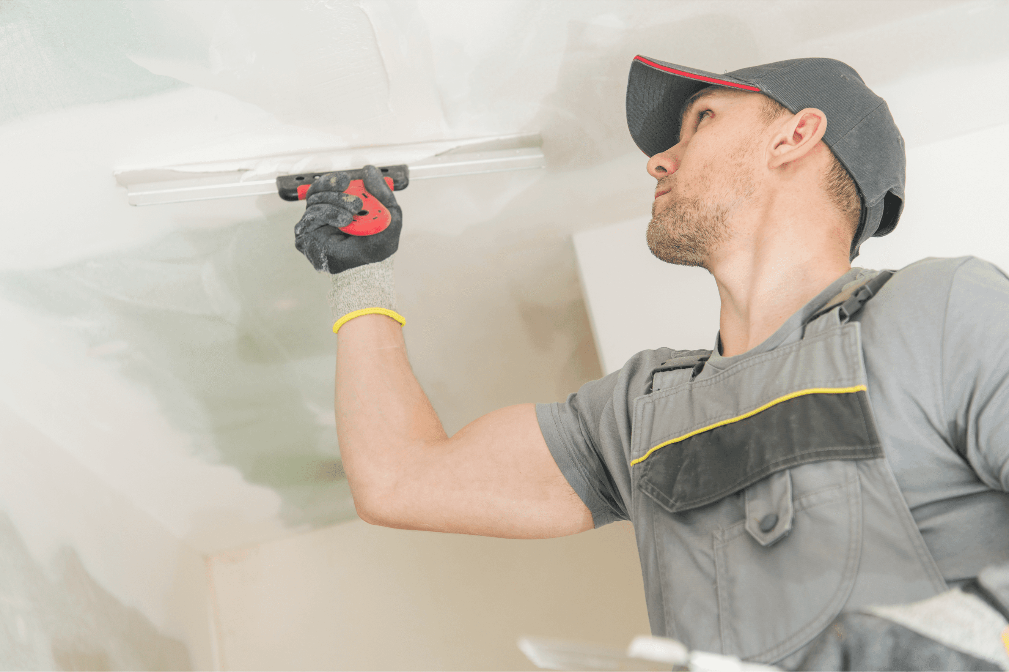 young man doing professional drywall on the ceiling