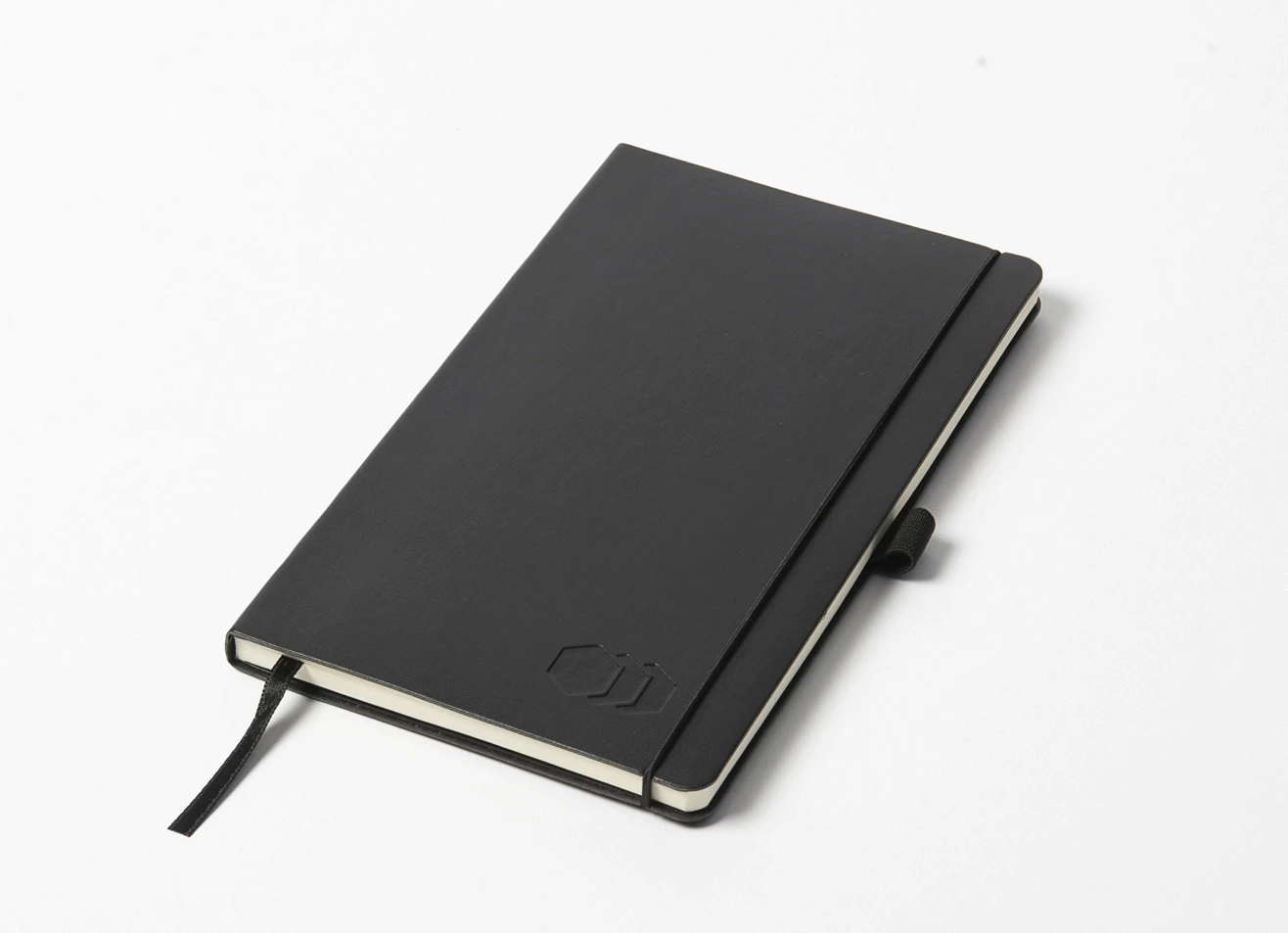 Angled view of black notebook with embossed hexagonal logo and closure strap.