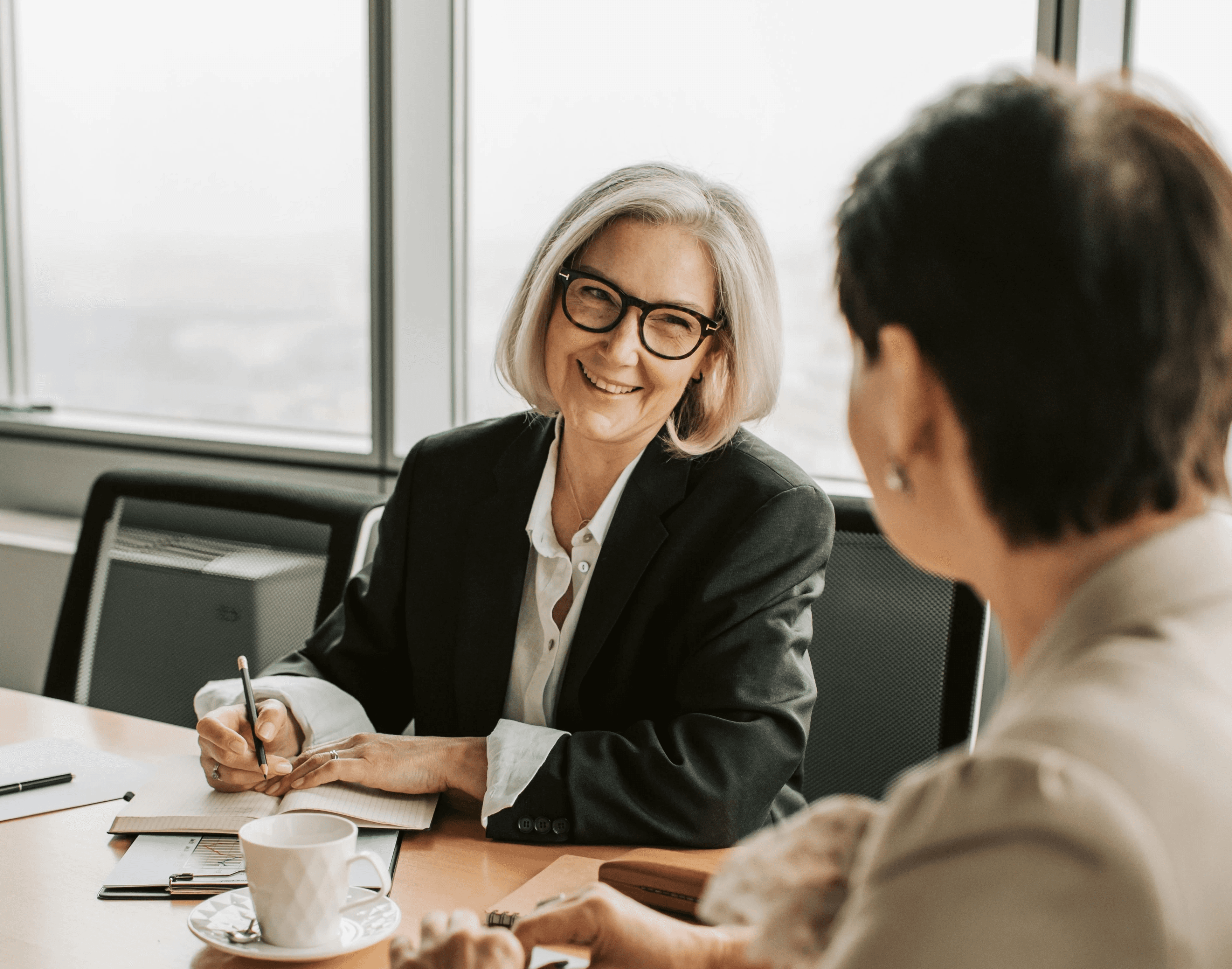 A financial advisor meets a retirement saver at a table, suggesting using Pontera for managing held away assets.