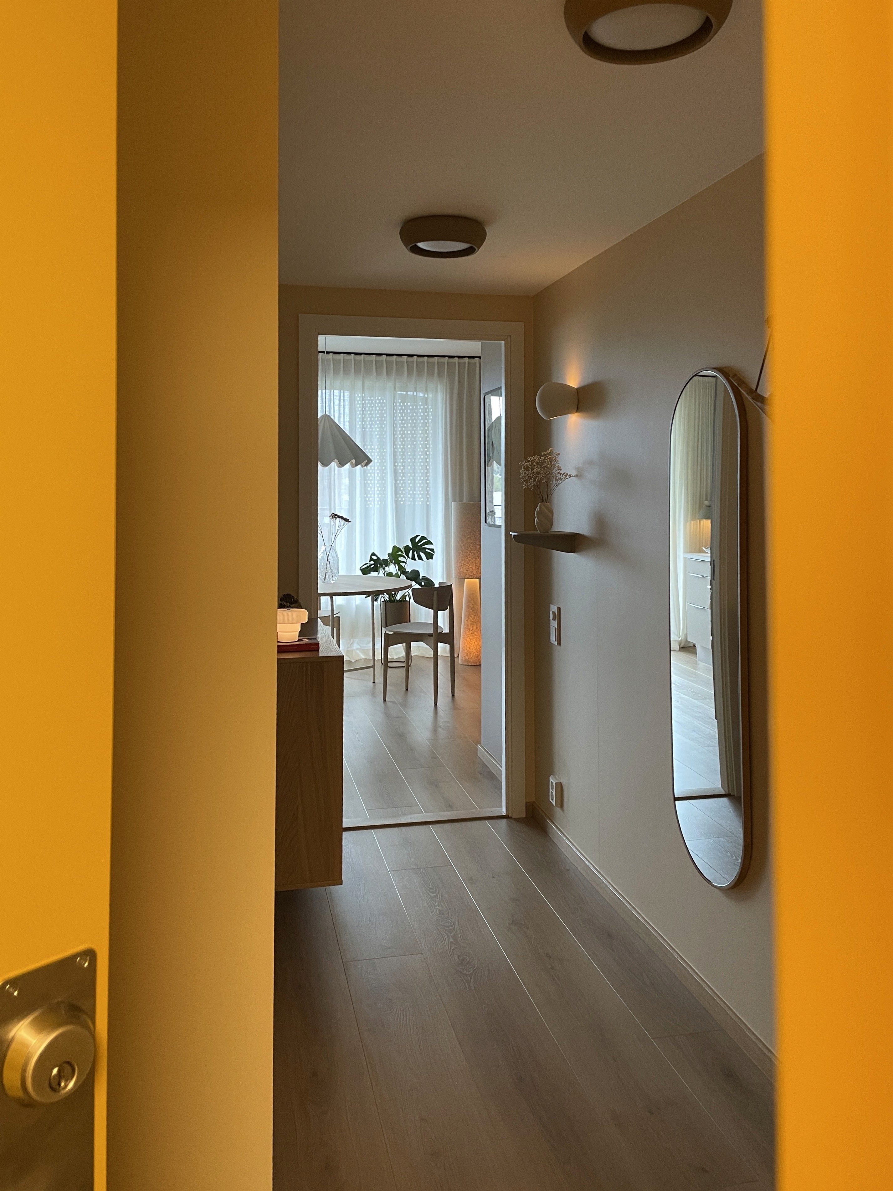 Entry hallway with an oval mirror and a view toward the studio dining area.