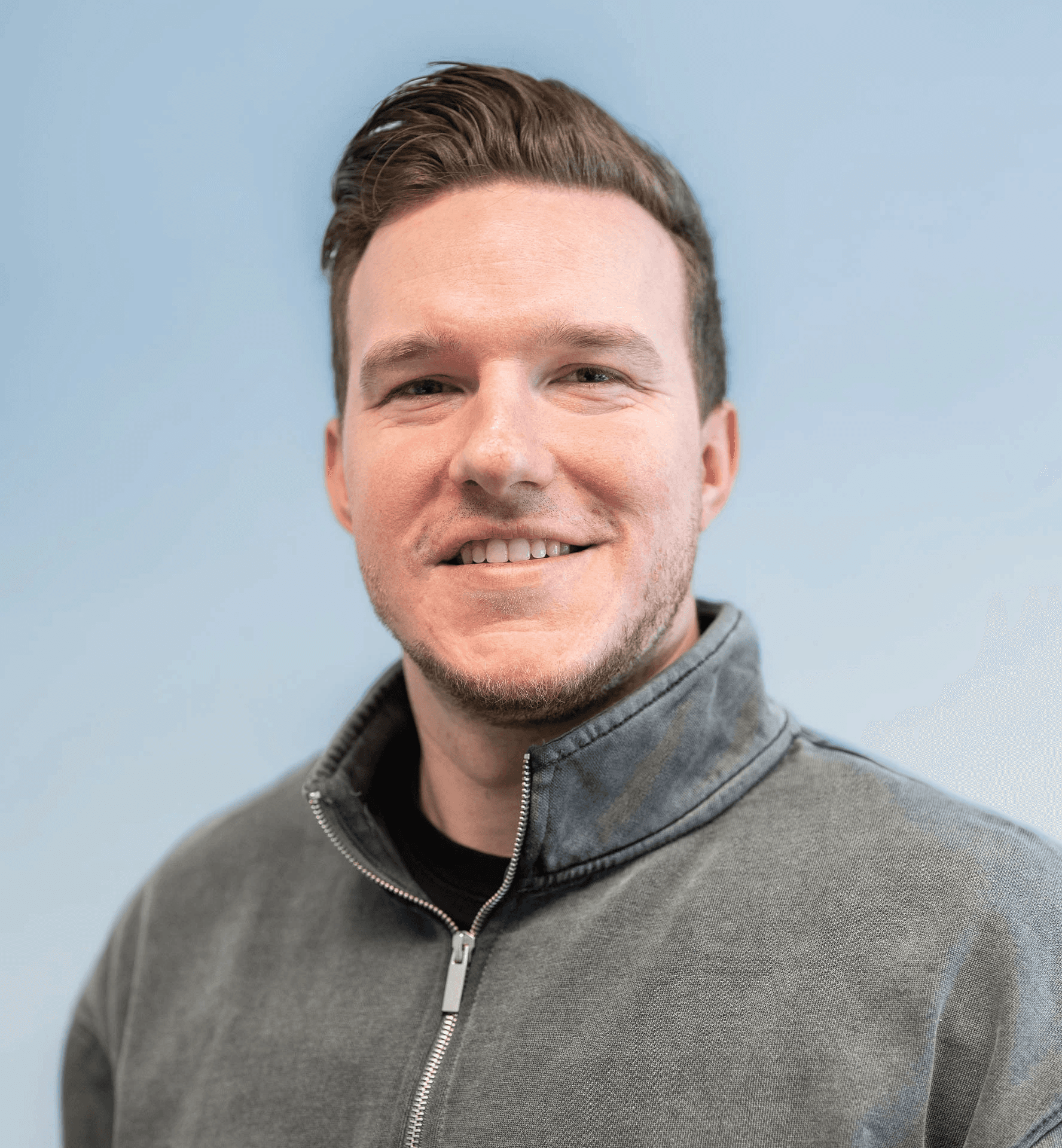 Portrait of a person in a pink sweater against a light background