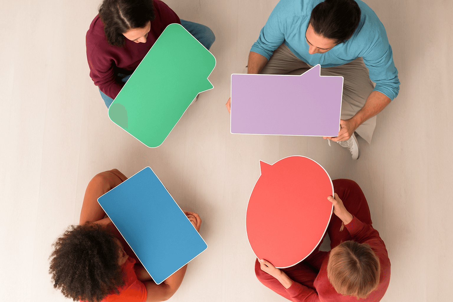 Image of 4 adults holding speech bubble cut-outs.