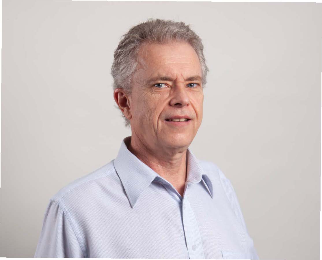 a man in a blue shirt smiling at the camera
