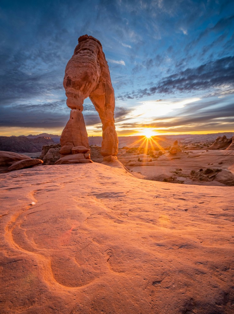 An arch rock formation at sunset