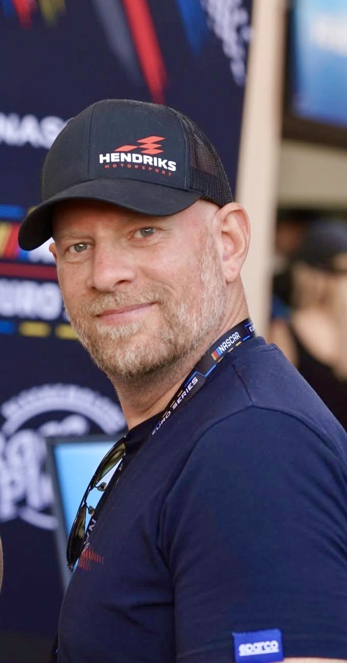 Henrik Peters wearing a Hendriks Motorsport cap in the NASCAR paddock
