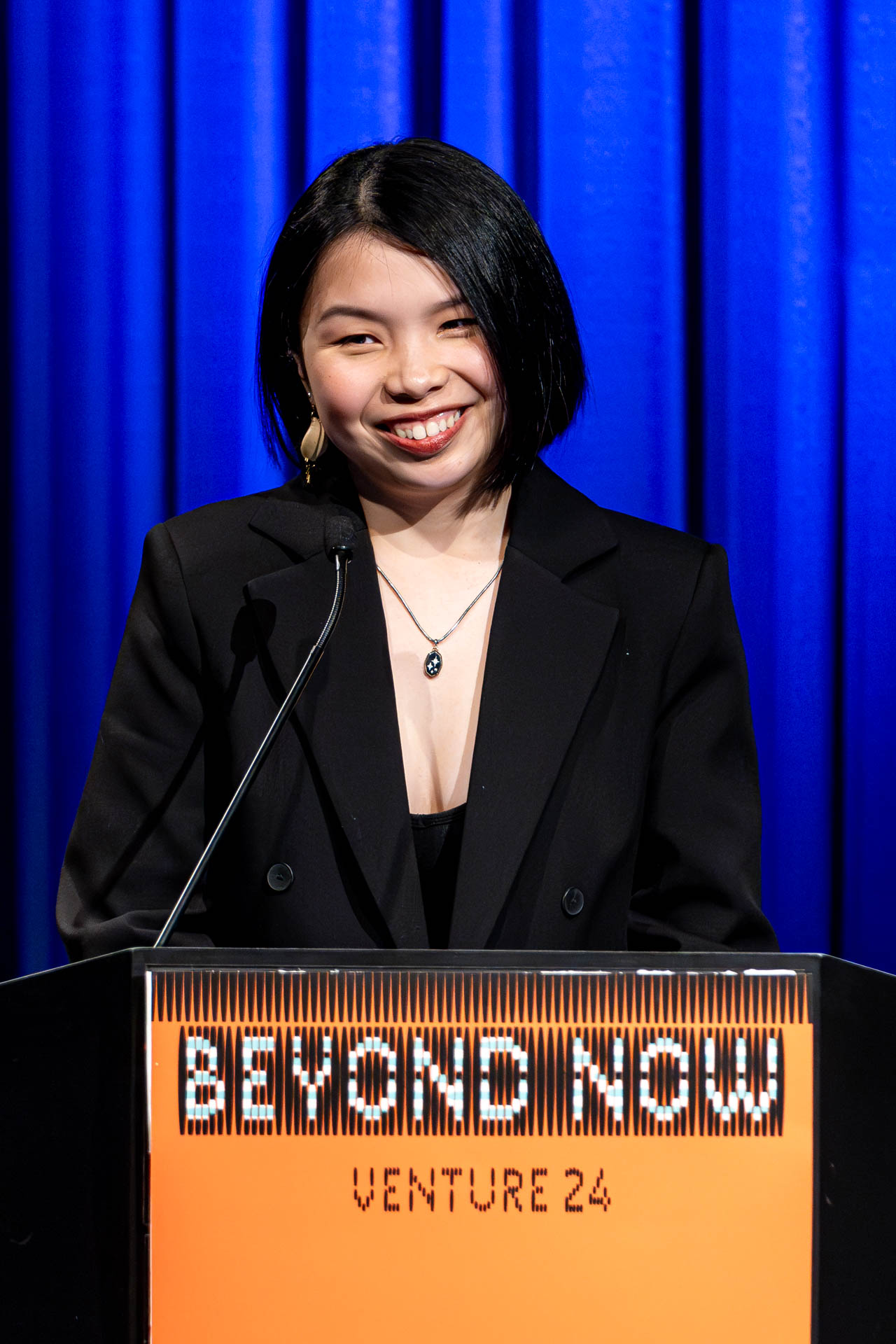 a student at a podium presenting a project in a Theatre