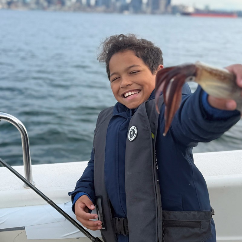 King on a boat holding a squid