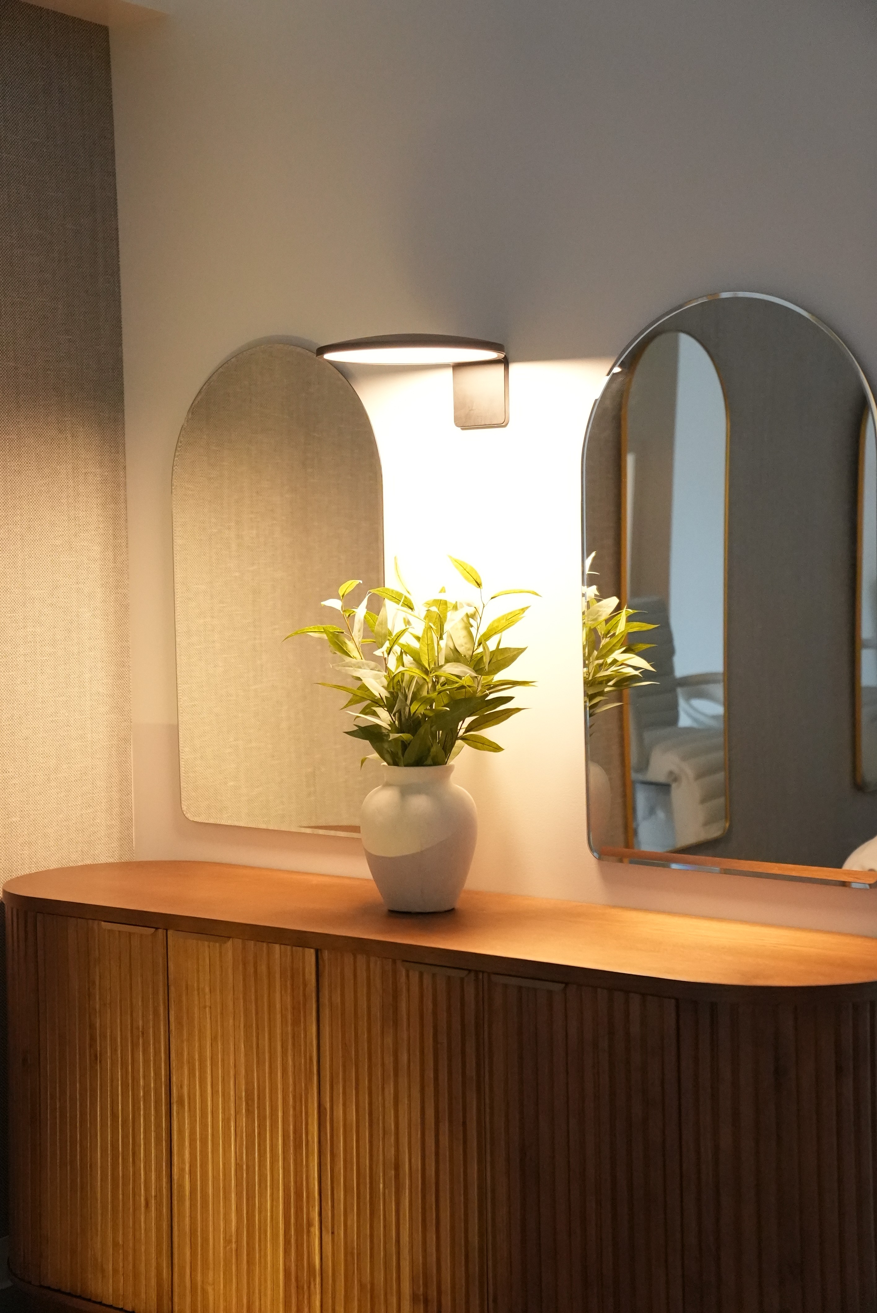 A serene spa setting with two lounge chairs beside a warm, reflective pool and soft, natural lighting.