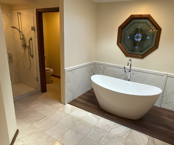 Bathroom remodel with freestanding soaking tub, wood accent flooring, and glass-enclosed shower
