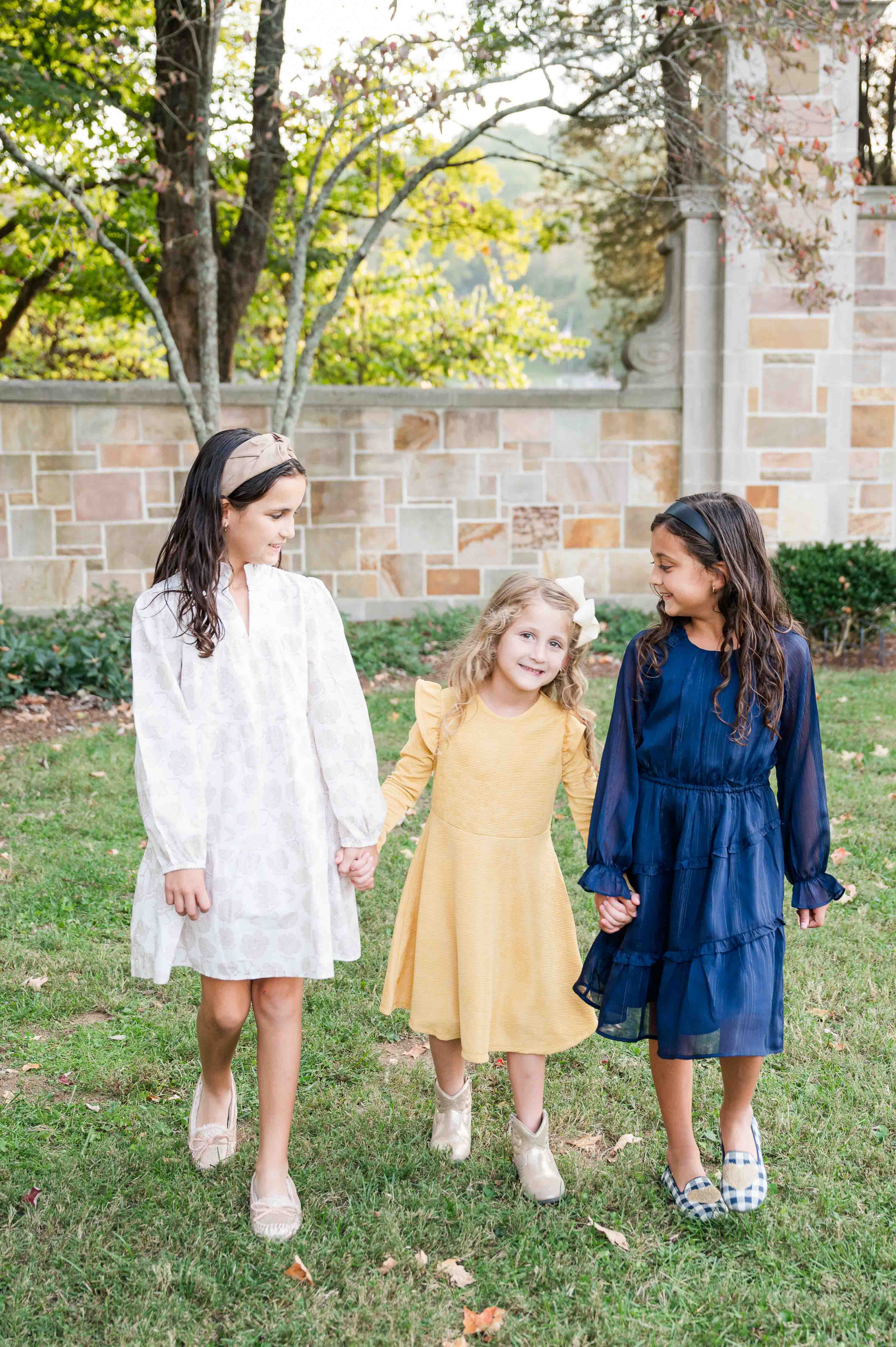 Family mini session portrait of sisters walking and laughing.