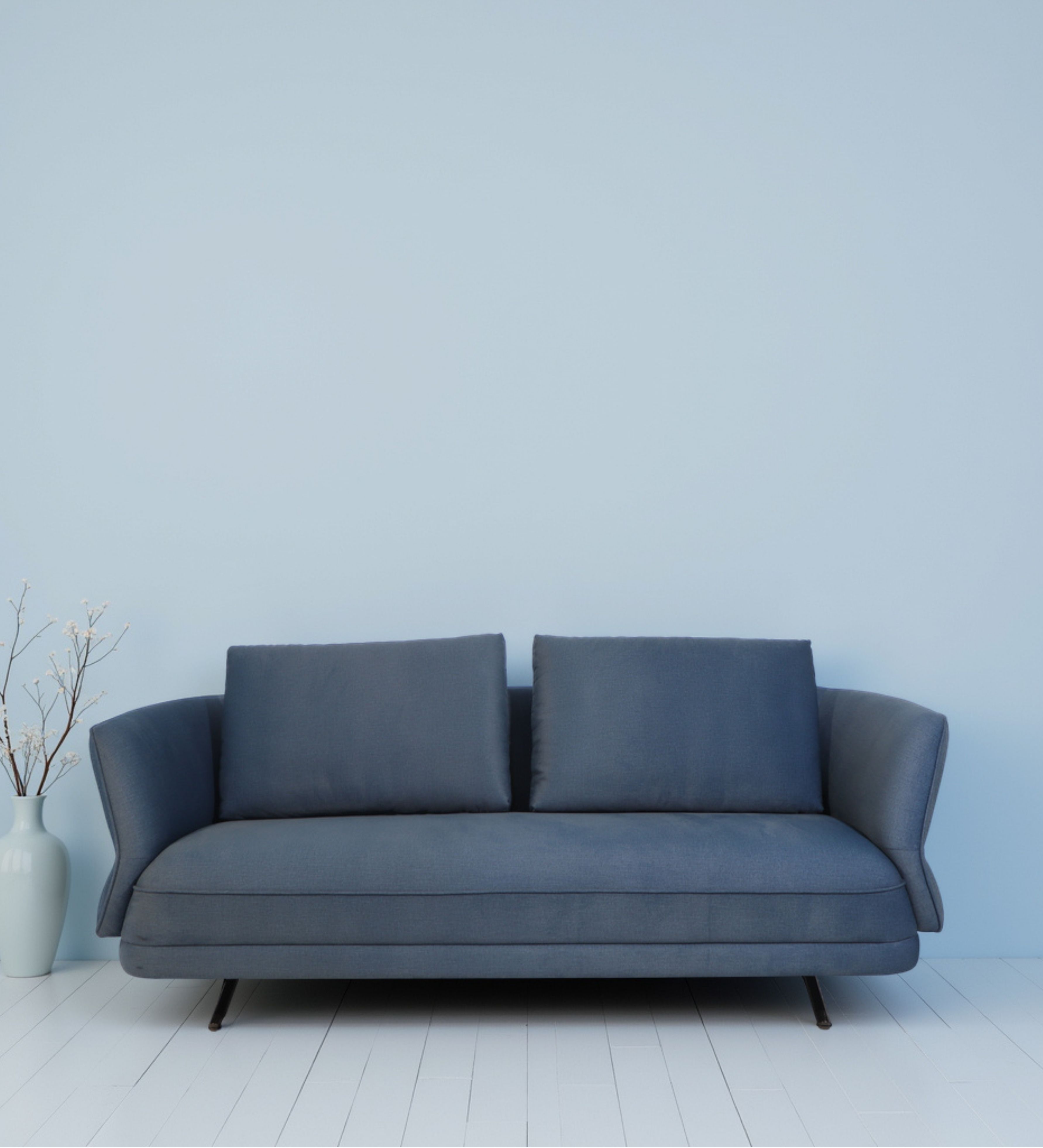 Blue fabric seating with softly curved arms and slim metal legs