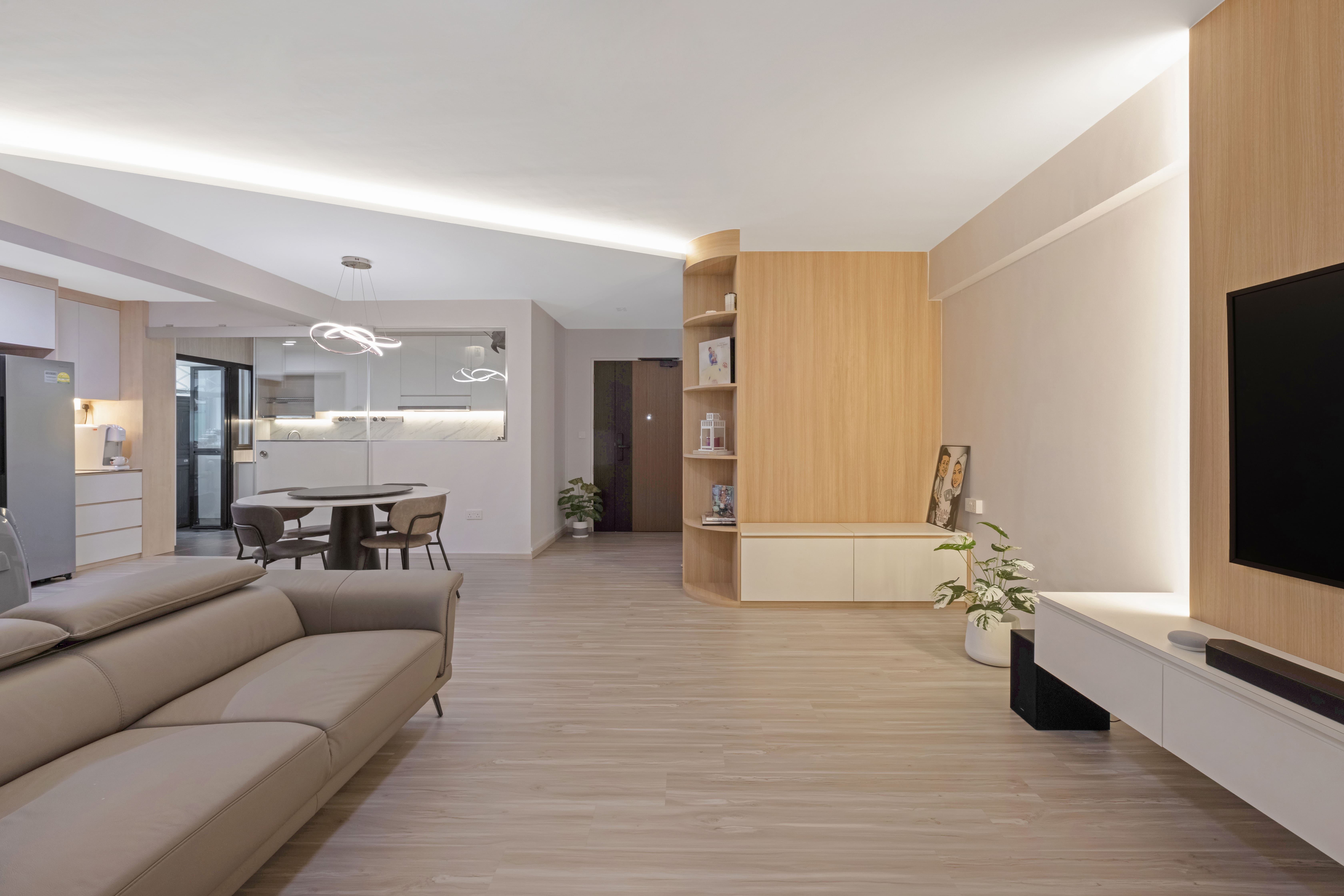 Spacious open-concept living room, featuring neutral wood tones, a streamlined TV wall, and versatile shelving that blends form and function.