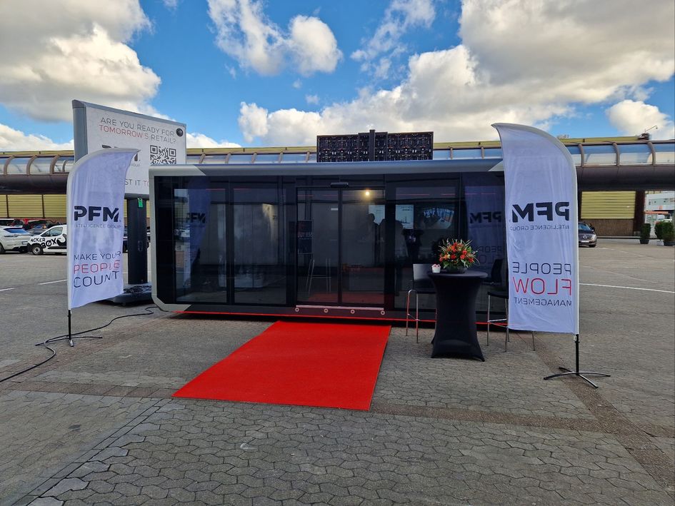 A large truck with a crane parked under clear blue skies and surrounded by palm trees.