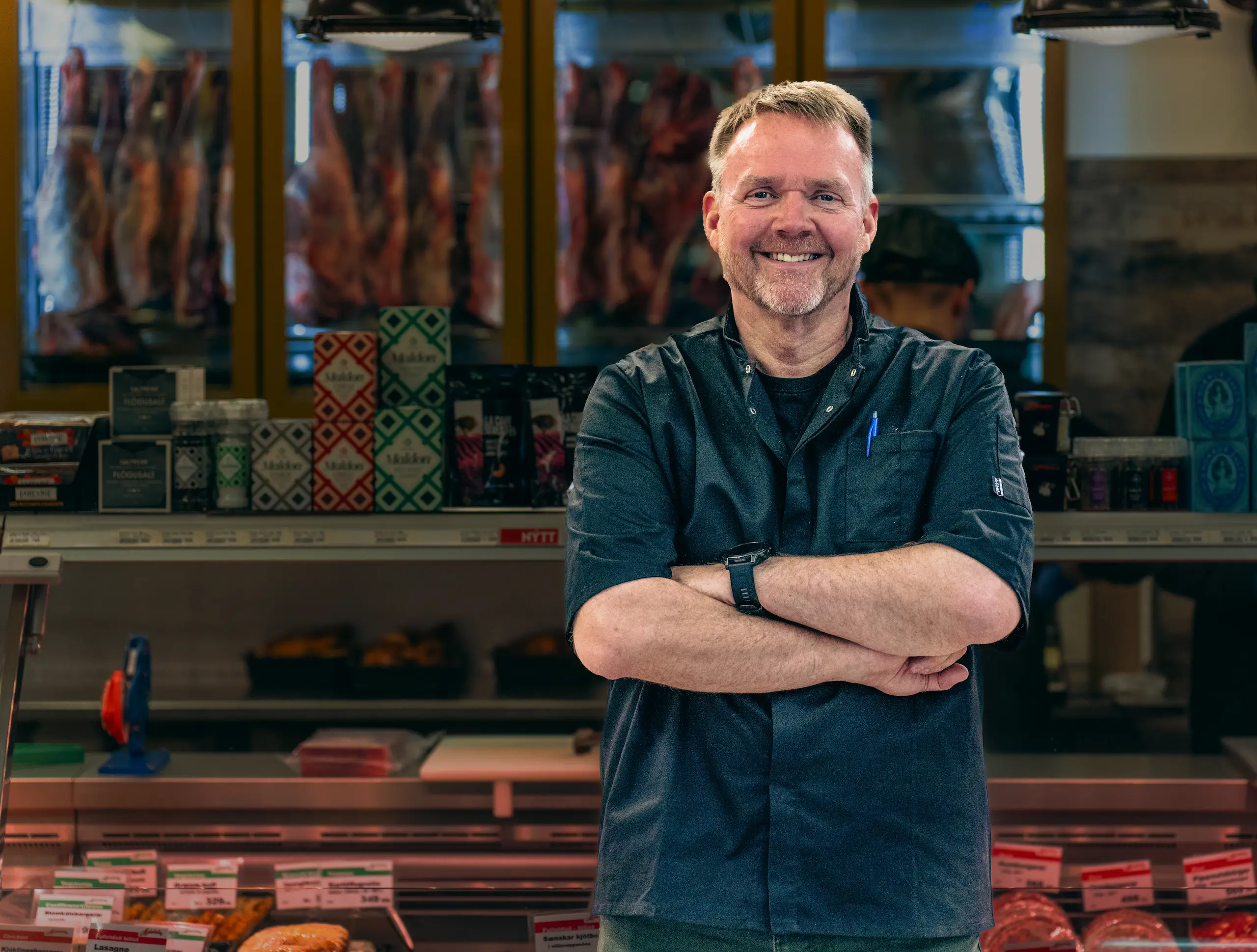 Small business owner smiling in their shop, using Teya Business Account
