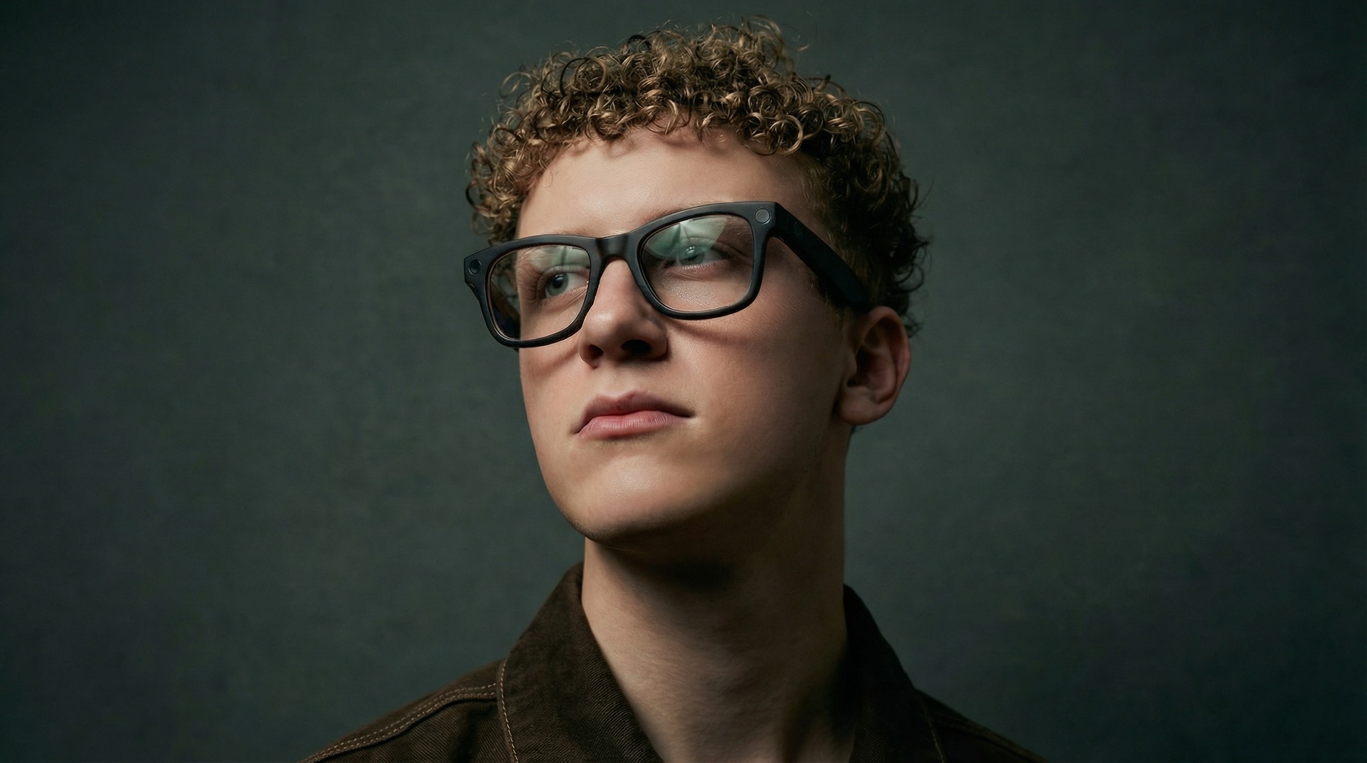 A close-up of a hand wearing multiple decorative rings against a blue background.