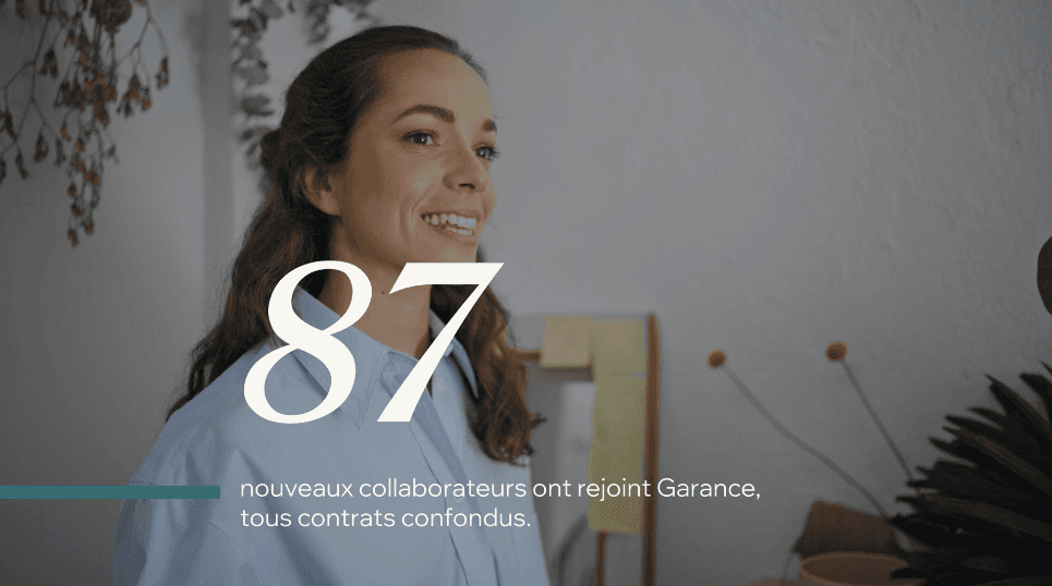 Two people walk across a snowy landscape with ski poles, leaving trails in the fresh snow. The scene conveys calm and solitude.