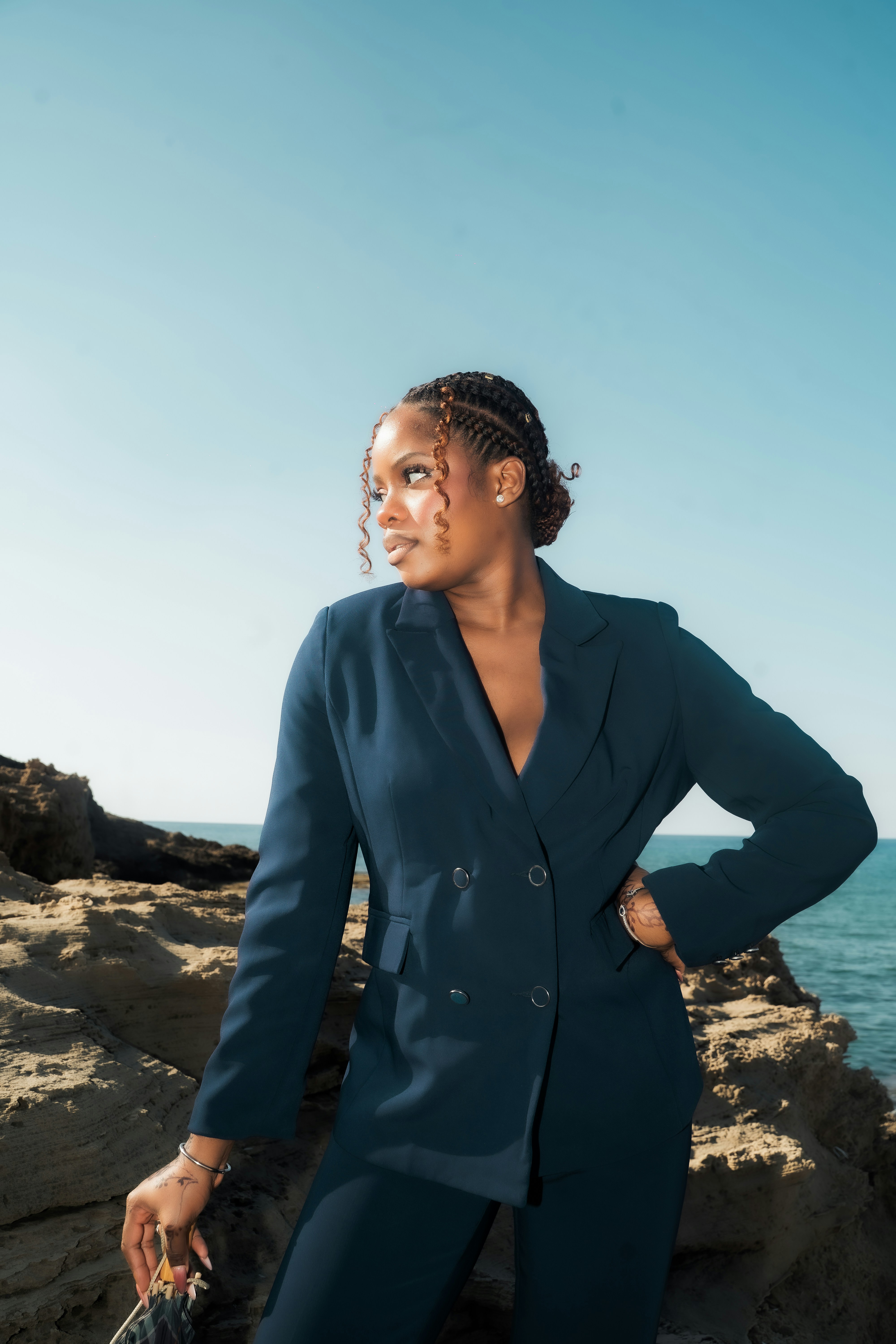 Woman in a navy blue suit by the ocean