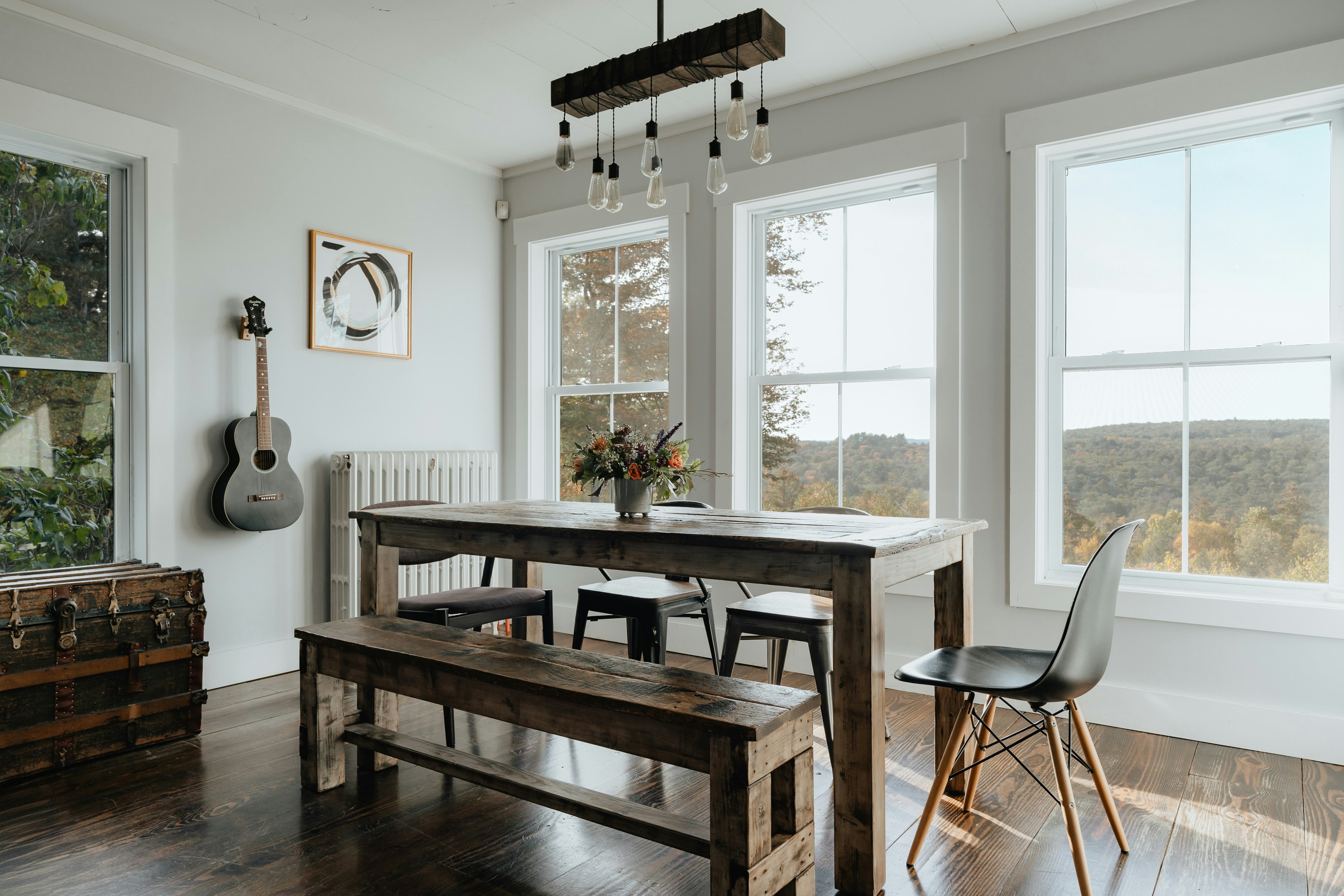 A farmhouse dining table with benches under big windows
