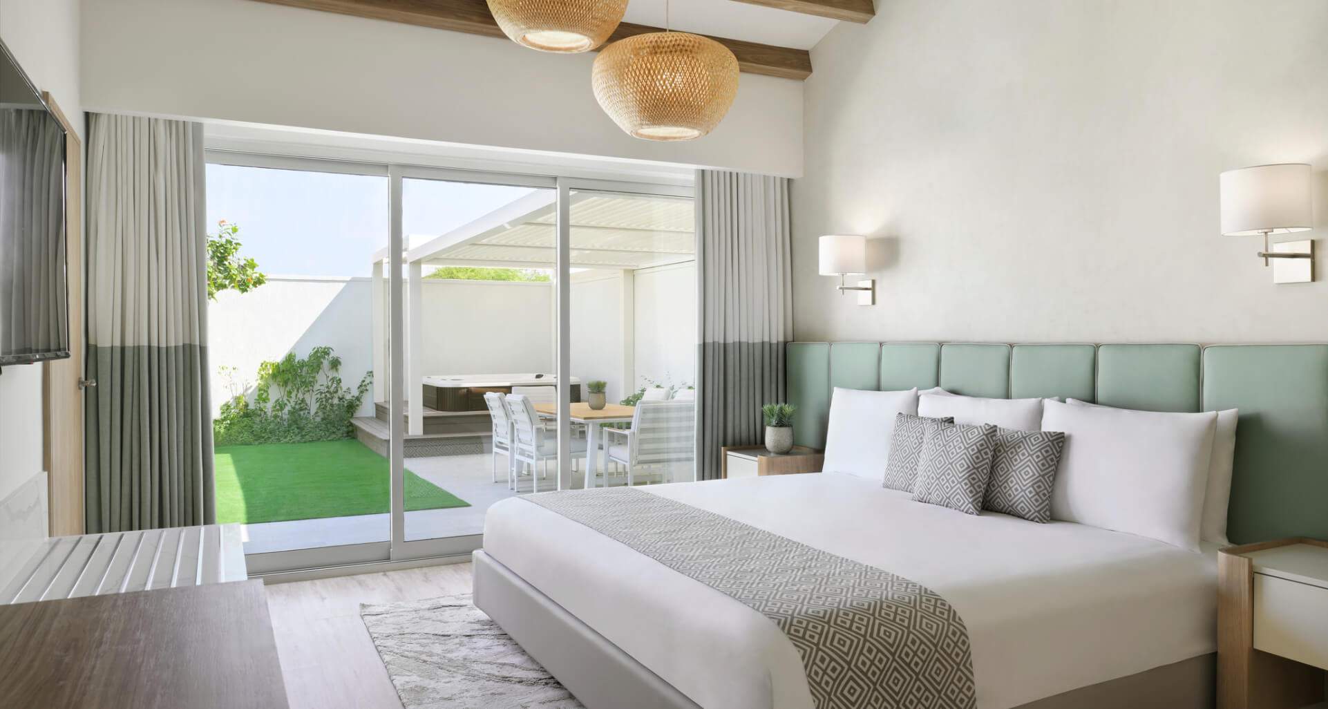 A pet-friendly hotel room in Dubai with a clean design and an outdoor area near the bedroom separated with glass sliding doors.