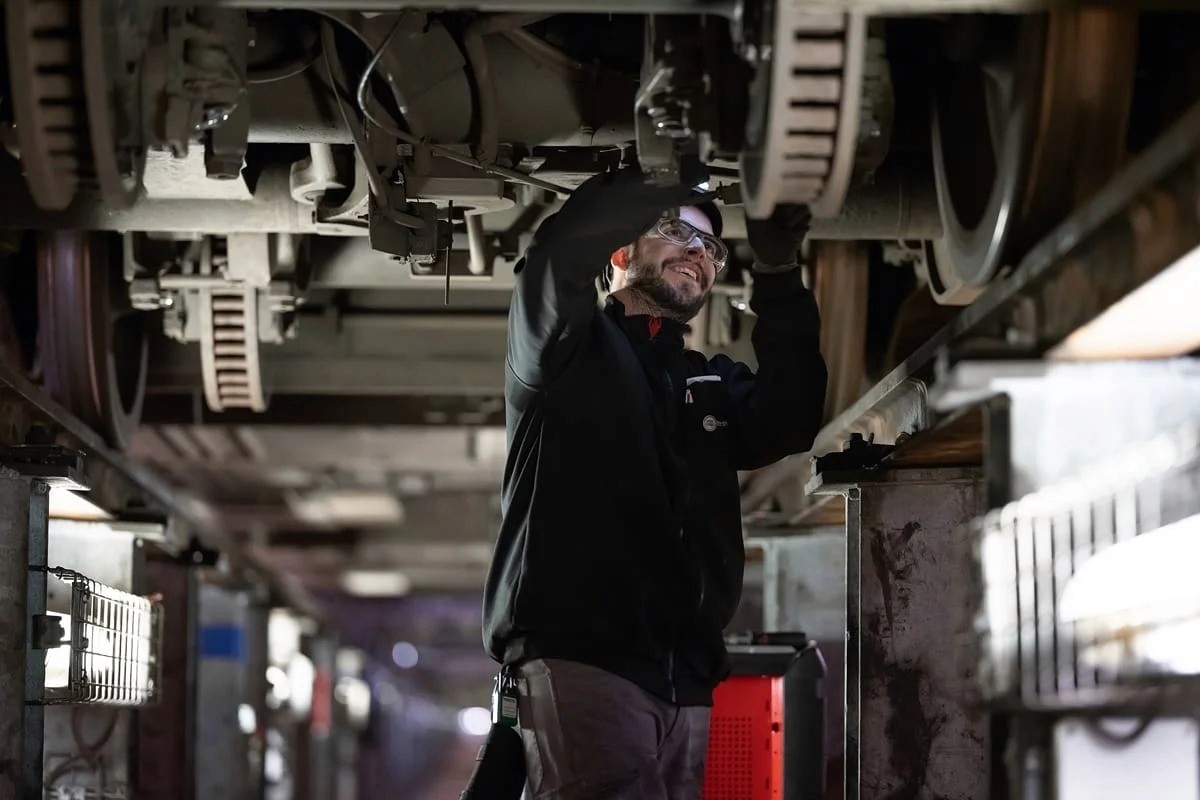 Mécanicien sous wagon vérifiant essieux — photo technique industrie Lille | Anteale Yann Manac’h 2025