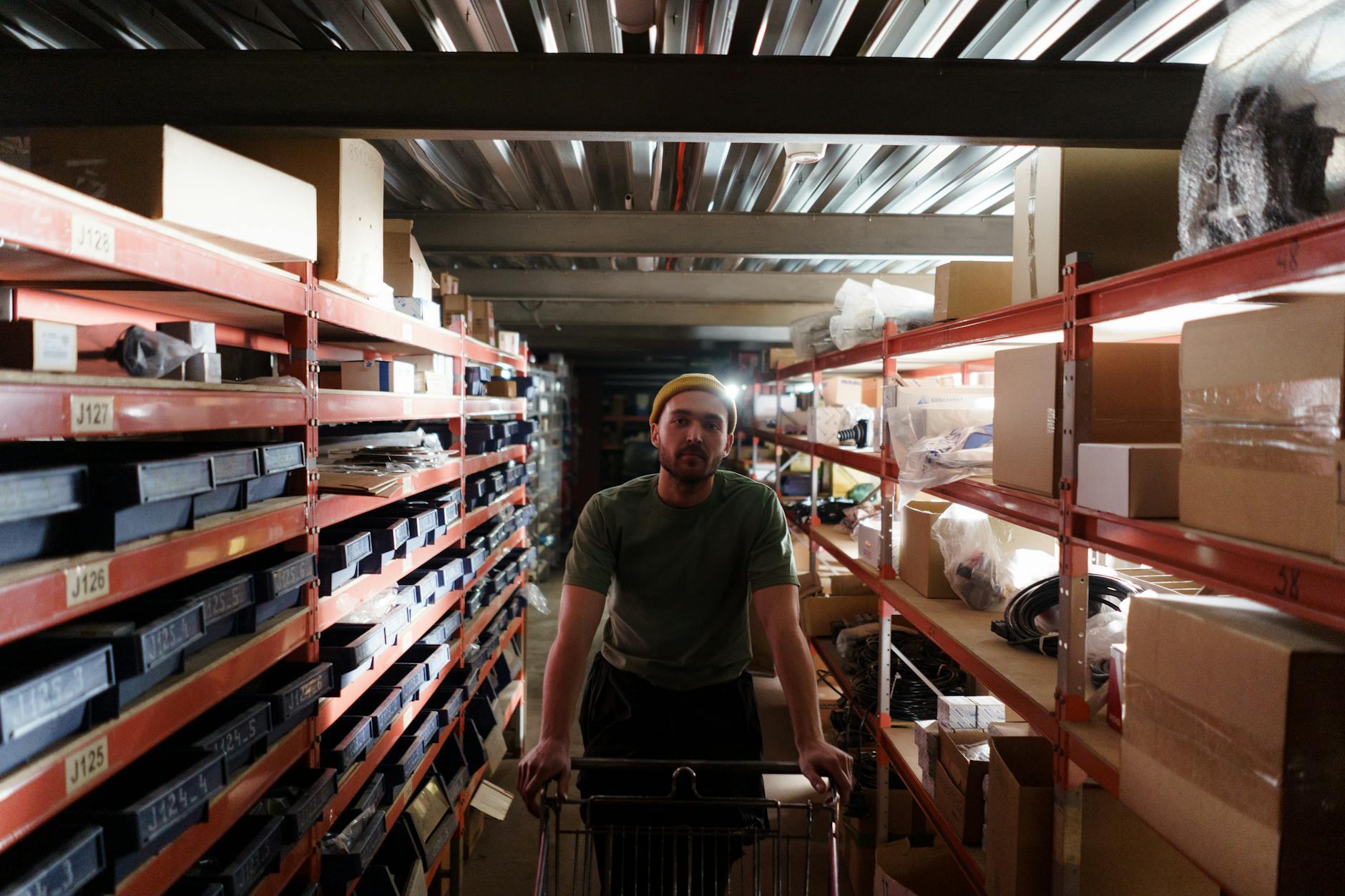 An overhead view of a person using a mobile phone to scan barcodes on boxes inside a scholastics warehouse.