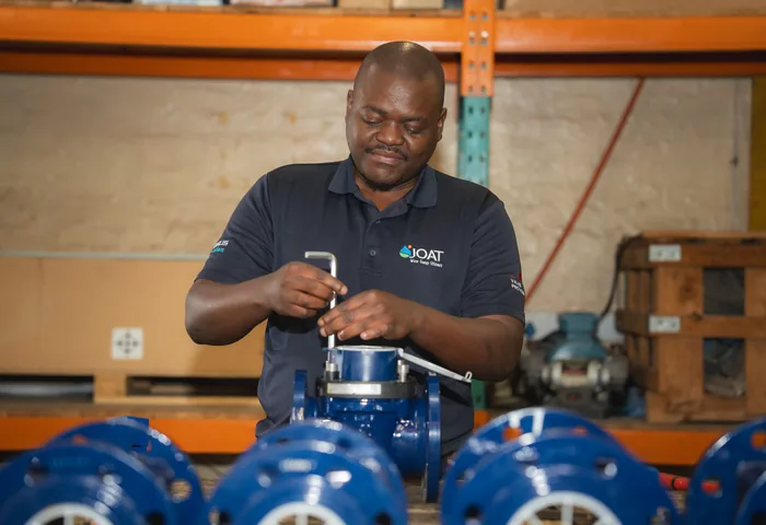 JOAT technician working on bulk water meters at the workshop bench