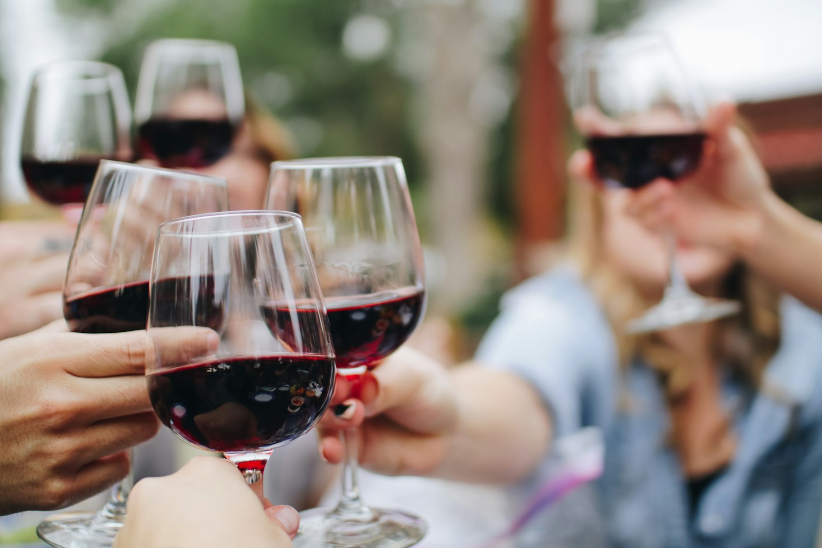 Friends raising glasses of red wine together at a tasting