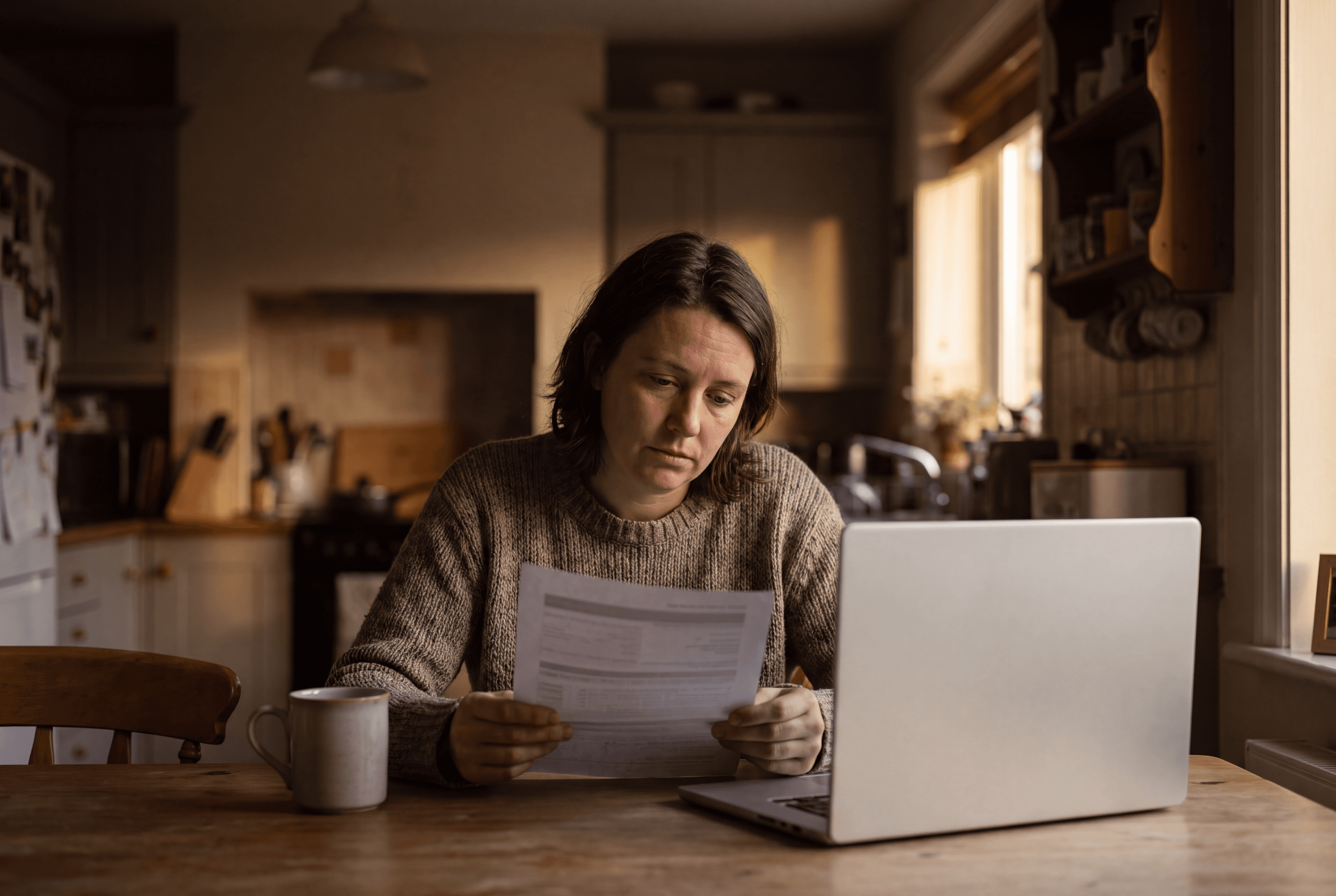 An employee reading a medical bill at their kitchen table