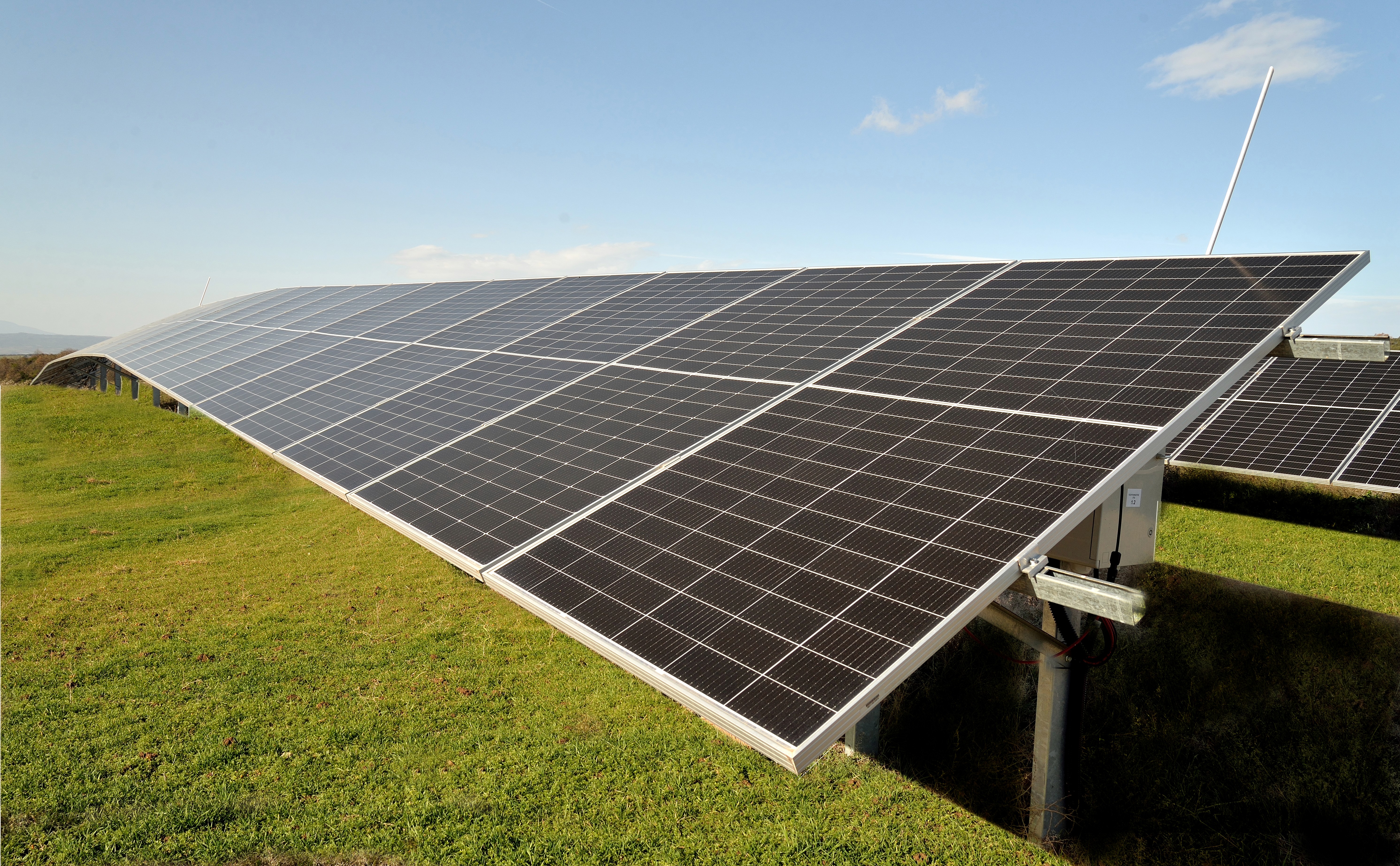 Low-angle view of ground-mounted photovoltaic panels highlighting solar module surface and alignment