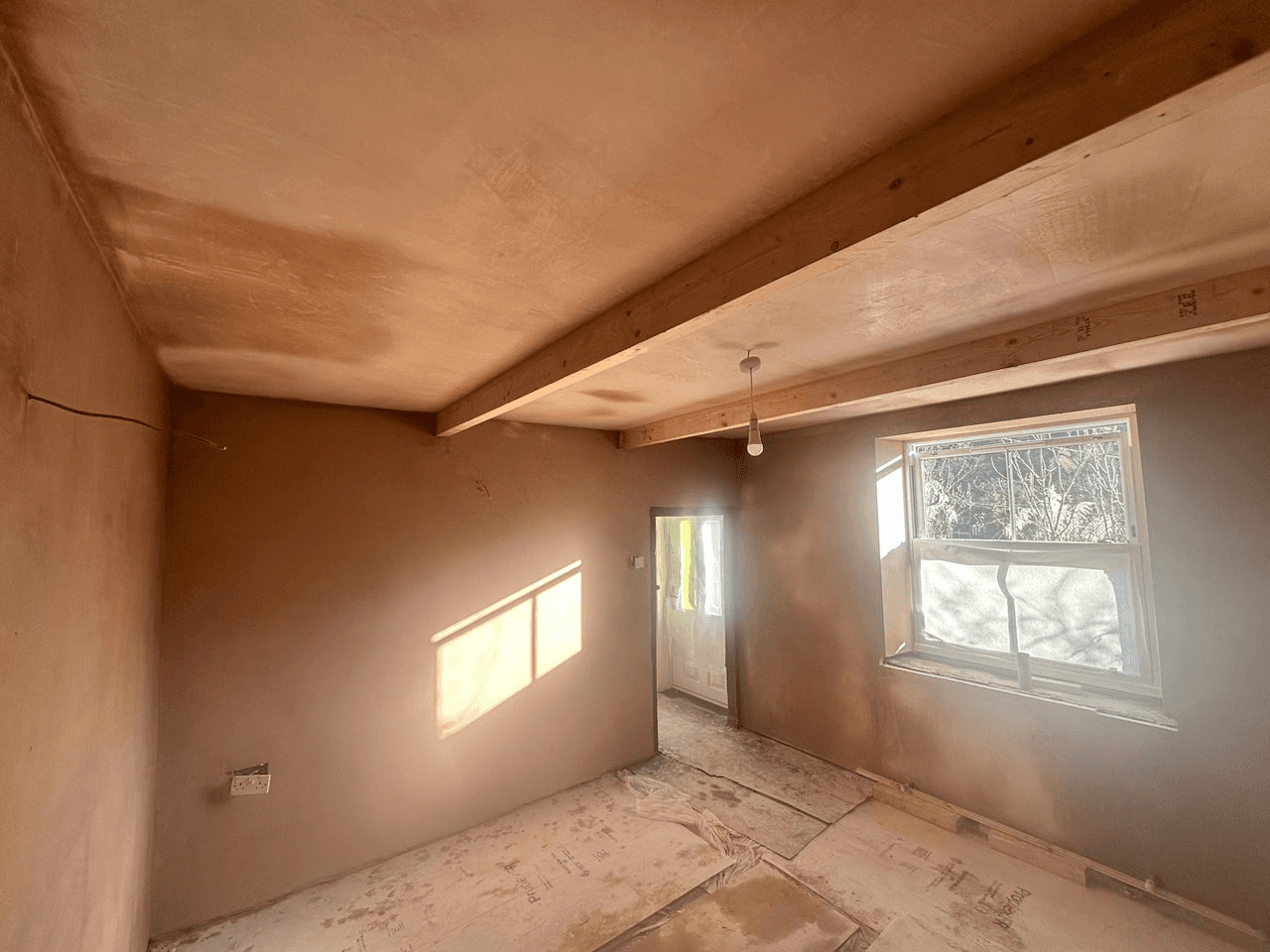 Cottage room with overboarded ceiling and complete skim.