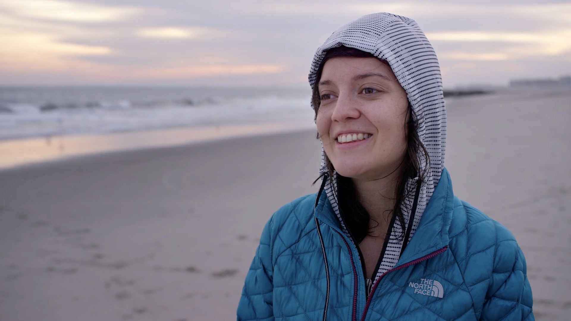 Modern home office setup with a monitor, ergonomic chair, keyboard, and indoor plants near a window with blinds.