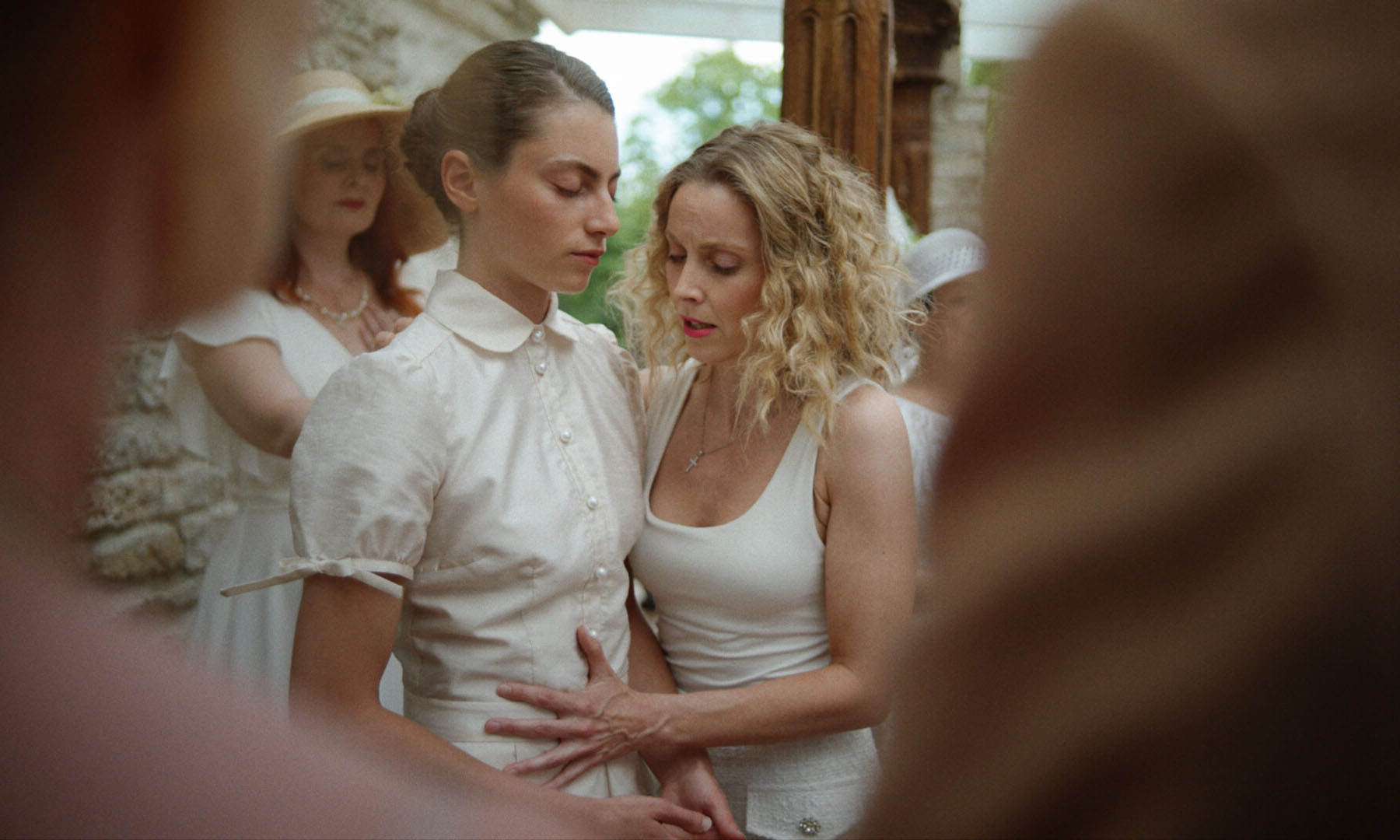 Maarja Johanna Mägi as Aurora standing nervously as another woman holds her in Aurora, an Estonian Nordic drama portraying fragile trust and tension.