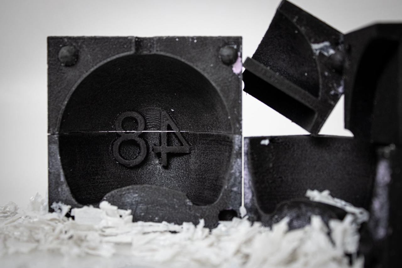 Close-up of a yellow tennis ball sitting on a green court, positioned near the white center line.