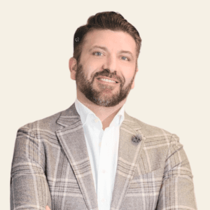 Headshot of Ed Khalili, smiling in a plaid blazer with a lapel pin.