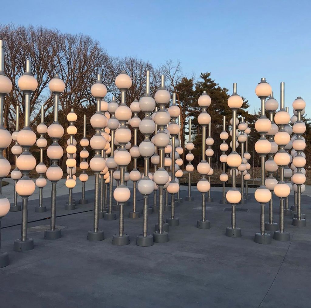 Glowing glass globes arranged throughout an outdoor public art installation